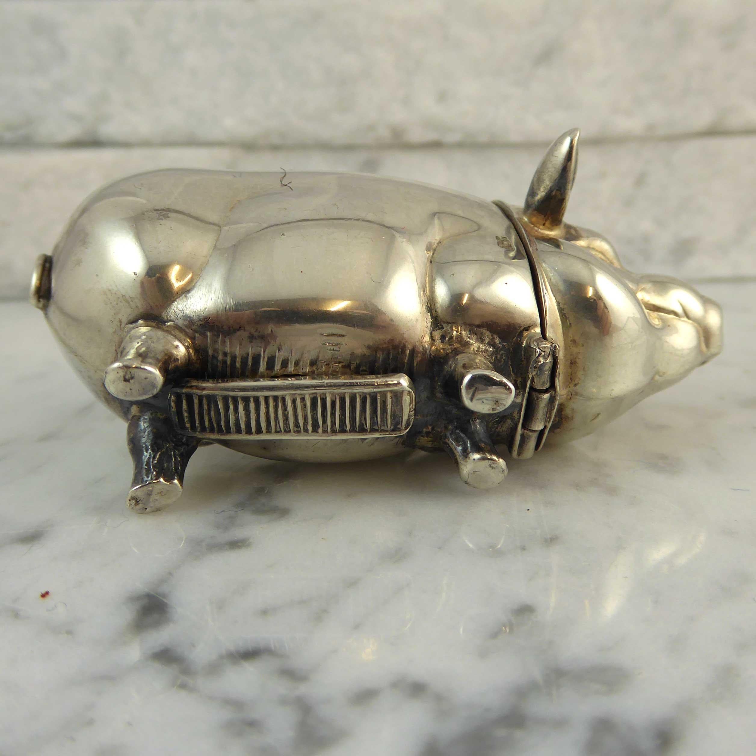 A recent, circa 2000, silver matchbox in the shape of a pig.  The head is hinged and falls forward to reveal a cavity for keeping matches.  The underside of the pig has a serrated section against which matches may be struck.  He has a lovely tactile