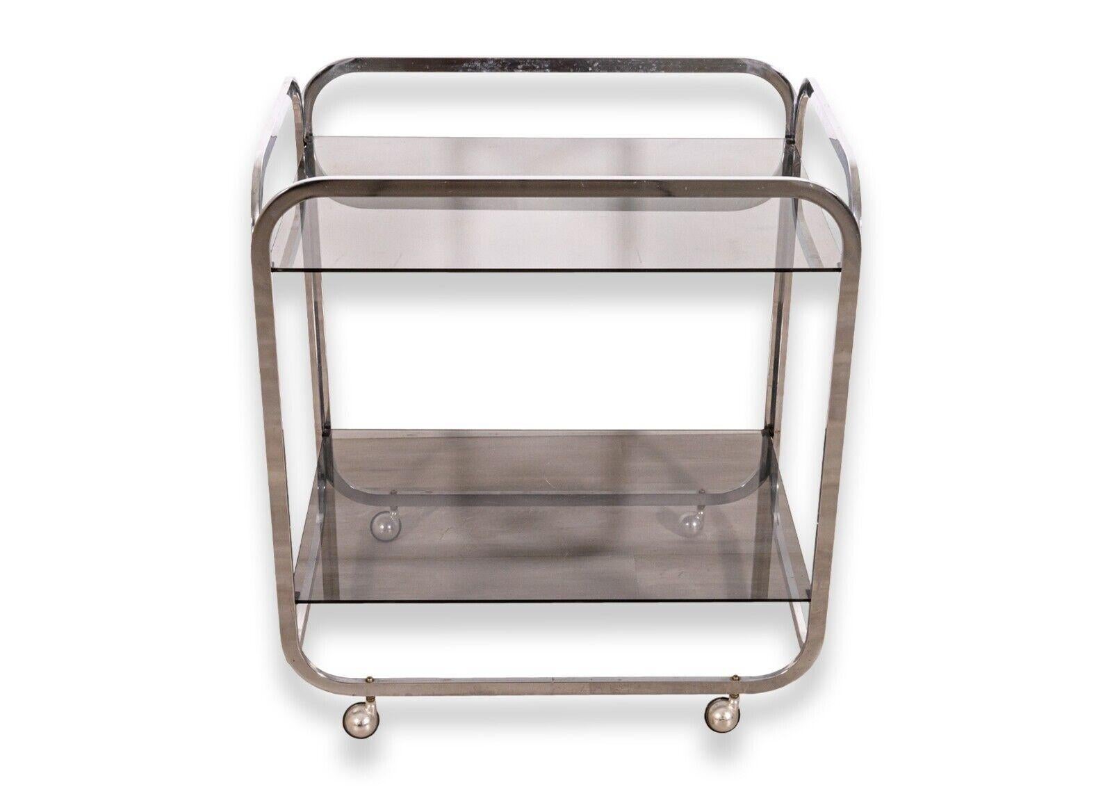 A two tier smoked glass and chrome rolling bar cart. A beautiful contemporary modern bar cart, a perfect addition to your modern dining room, kitchen, or office. This piece features a full chrome metal construction with two clean, smoked glass