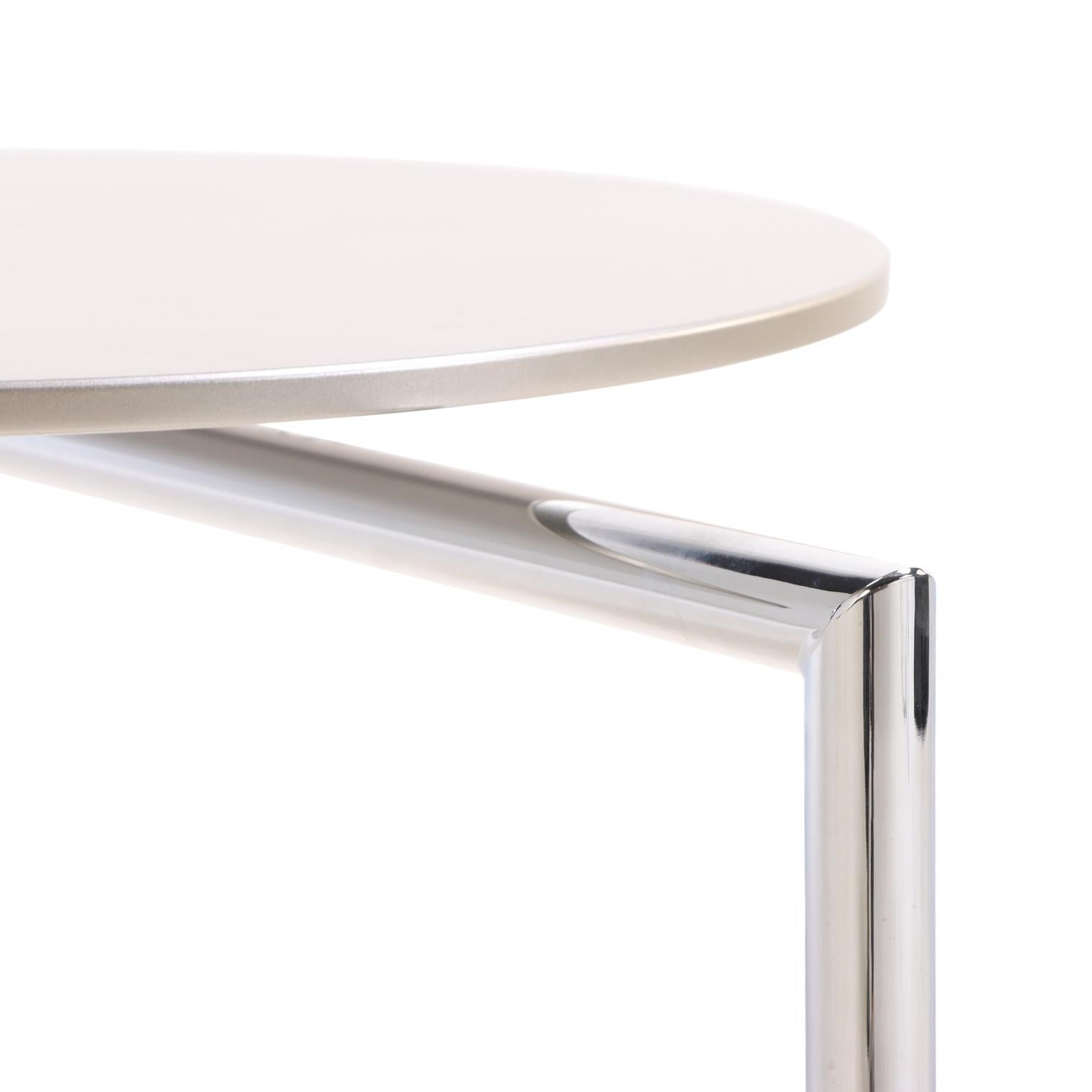 A contemporary cantilever side table with a circular laminate top and polished chrome base. Designed to perch neatly over the arm of a sofa or chair, the piece combines minimalist form with everyday function.
