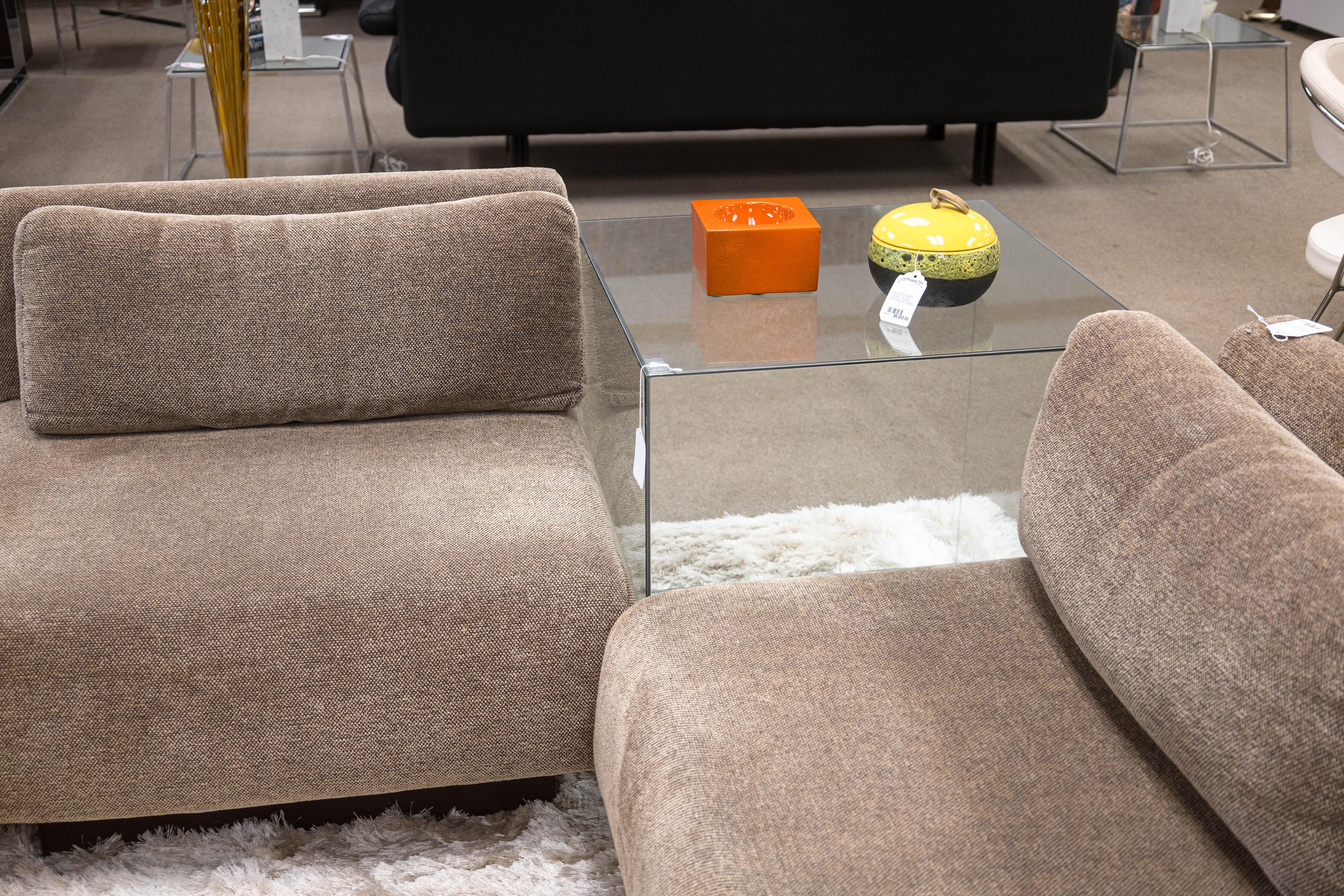 Un tavolo cubo di vetro modernista e contemporaneo. Si tratta di un tavolo d'accento moderno, semplice ma chic. Presenta un design a cubo di grandi dimensioni, realizzato completamente in vetro e con sottili rinforzi in metallo lungo i bordi. Il