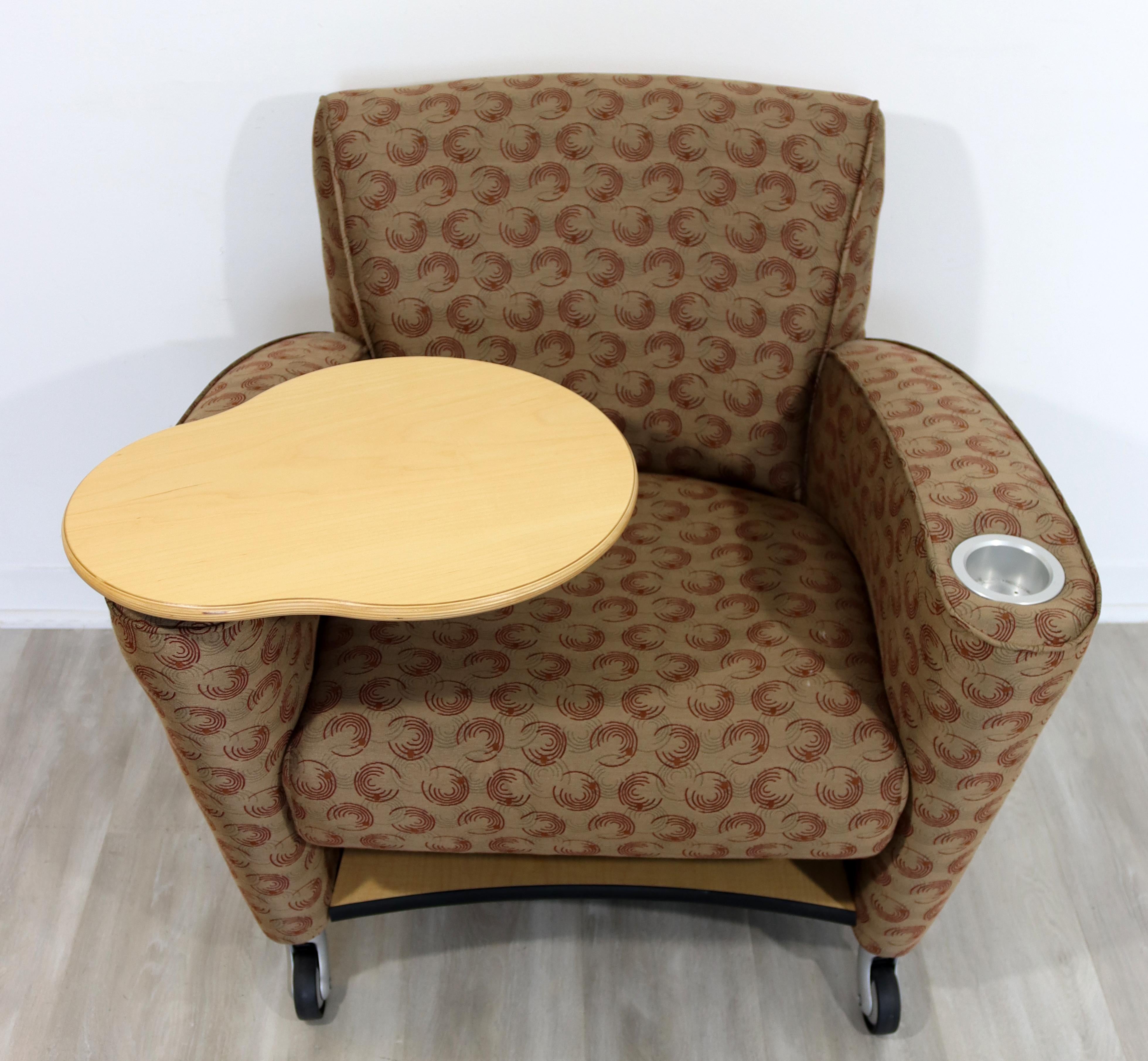 For your consideration is a beautiful, beige patterned fabric upholstered, tablet chair, with revolving table, by Loewenstein. In excellent condition. The dimensions are 34