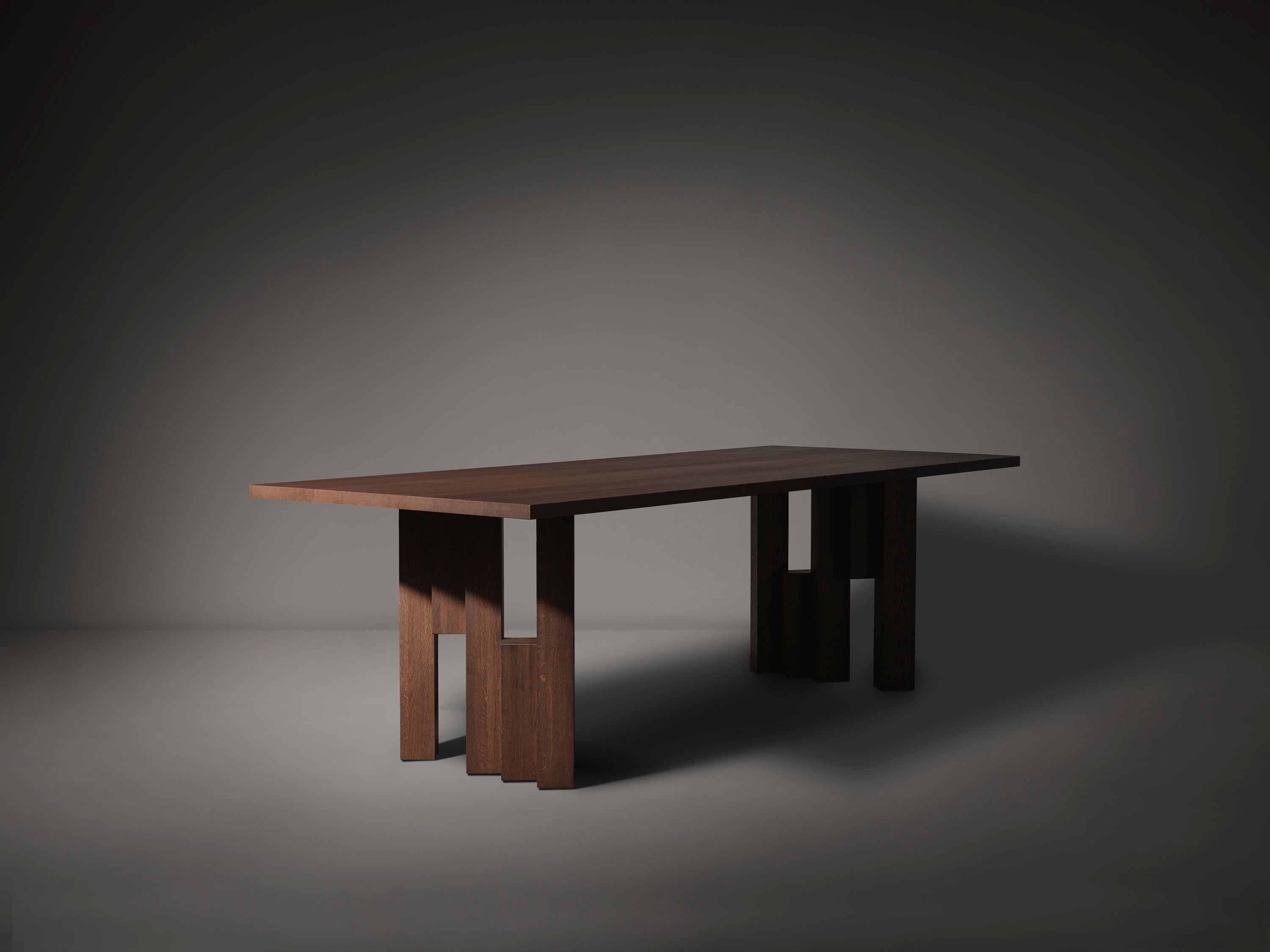 La table Fenestra, inspirée du style de l'école d'Amsterdam, est fabriquée en bois massif et sur mesure. Le design s'inspire de l'expressionnisme des briques, le mouvement architectural visible dans la zone du 