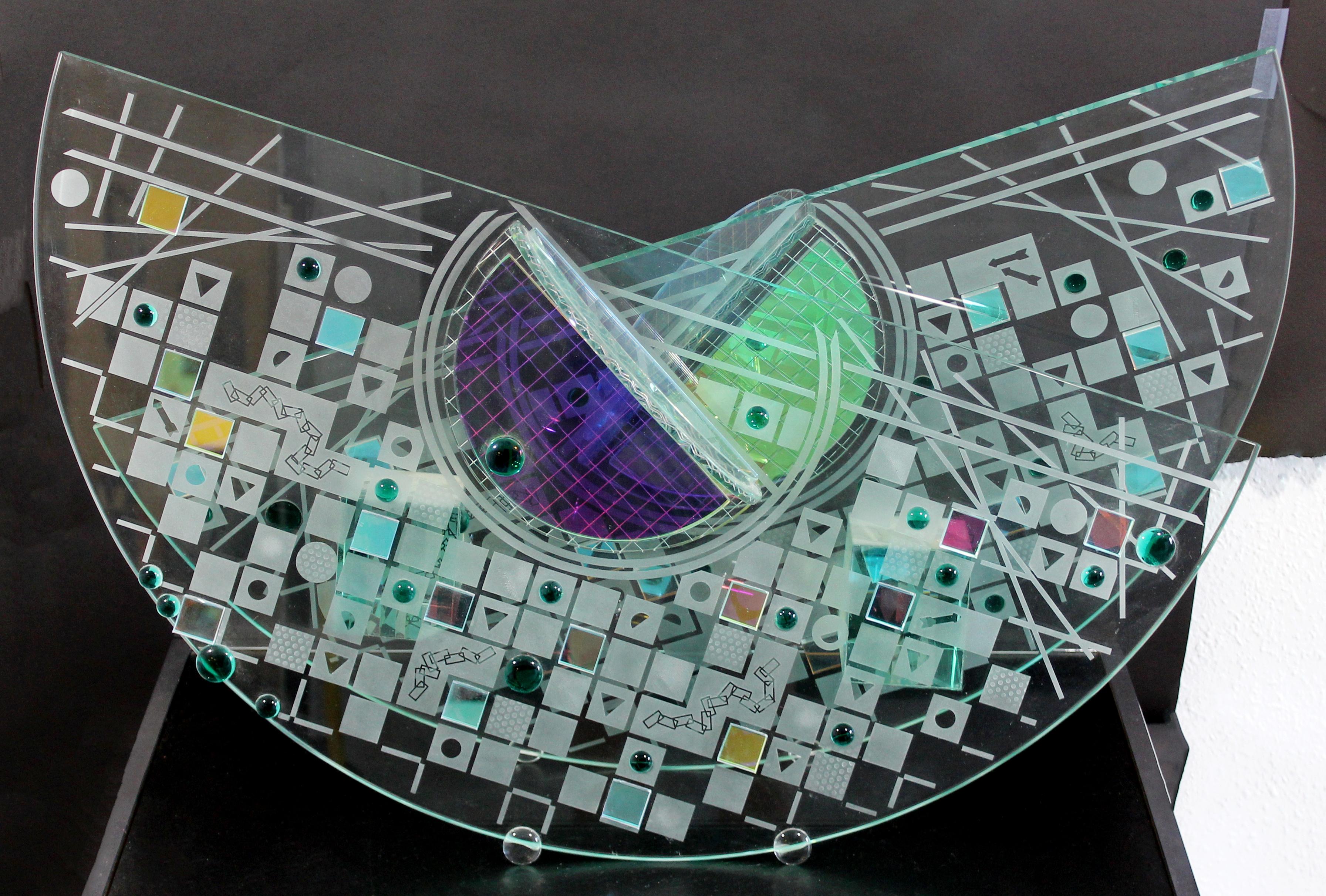 For your consideration is a luminescent, abstract glass table sculpture in the Memphis style, circa the 1980s. By renowned glass artist Toland Sands. In excellent condition. The dimensions are 30
