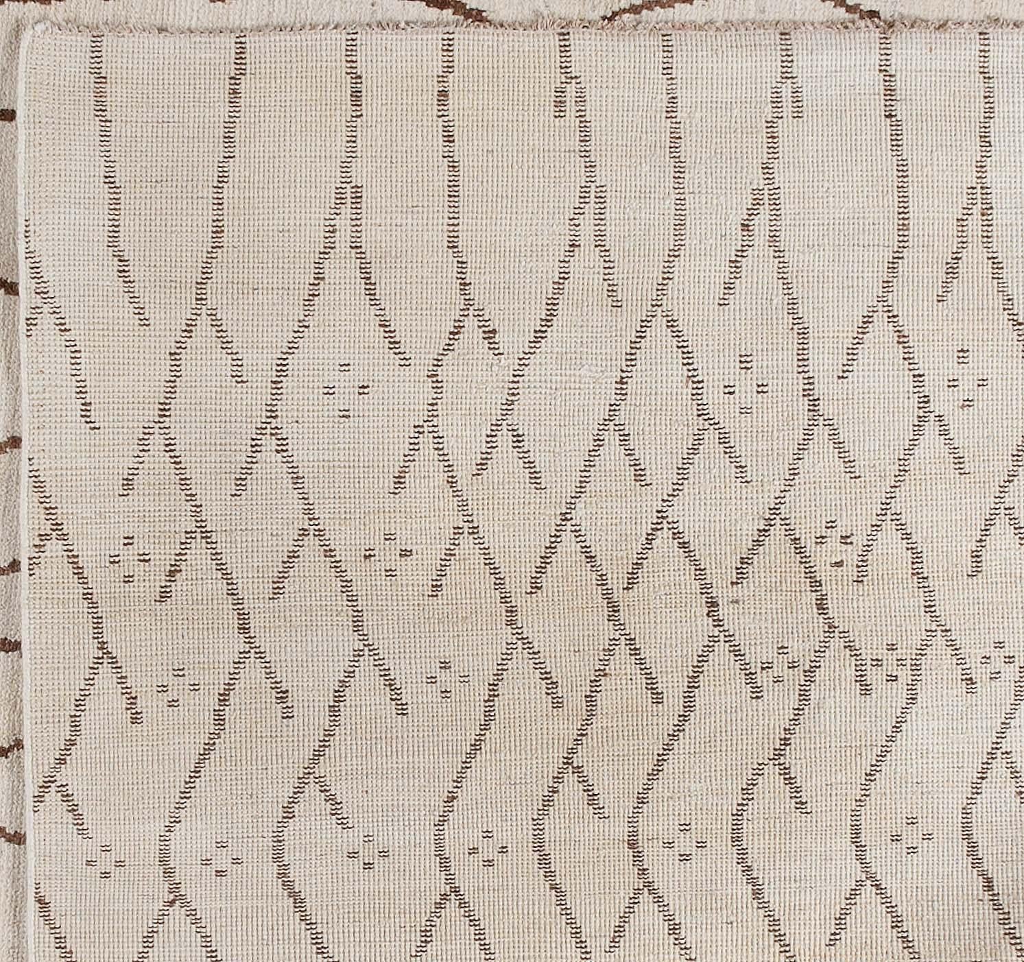 This simple Moroccan design with lines and shapes in contrasting brown and sand makes for a truly eye-catching piece. Hand knotted in Pakistan from a traditional Moroccan design. Wool.