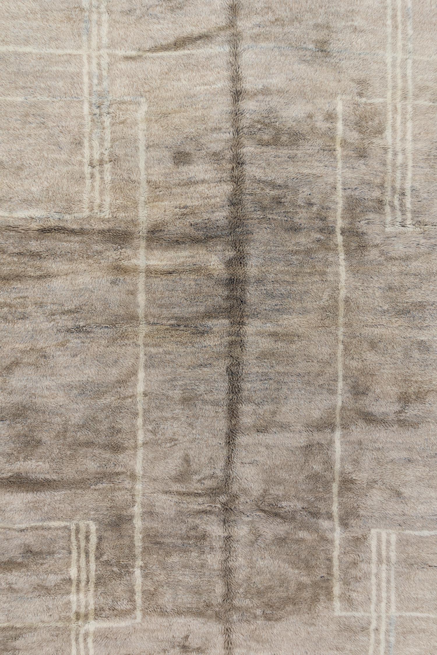 This Moroccan rug is crafted with wool from the Altas Mountains and offers a luxuriously soft texture and superior quality. It was hand woven in Morocco using traditional techniques and features a warm taupe field with subtle striped accents.

