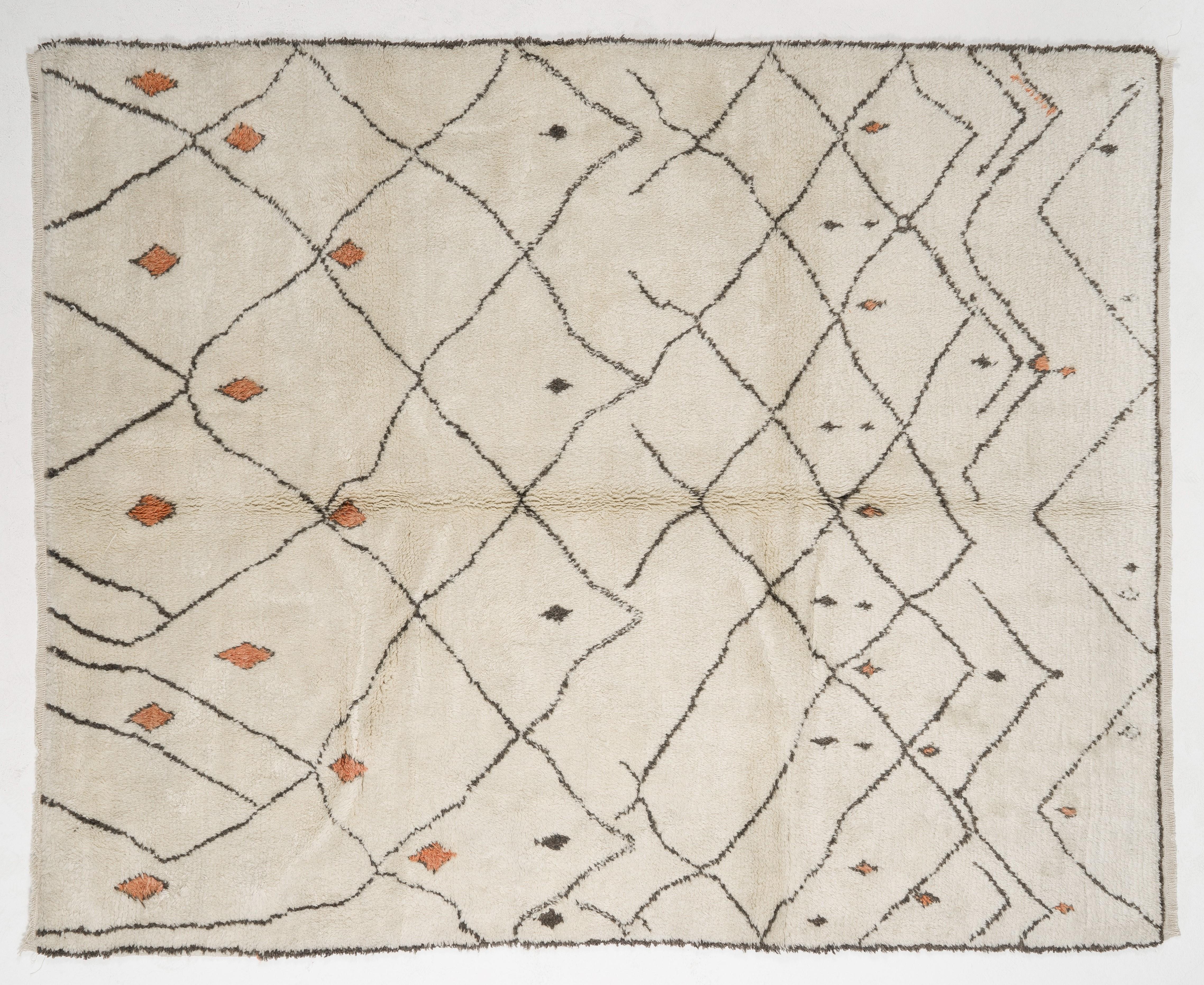Ein moderner, handgefertigter marokkanischer Teppich mit dickem, weichem Flor aus natürlicher, ungefärbter cremefarbener und brauner Wolle. Der Teppich zeigt ein modernes, sich auflösendes Rautenmuster mit einigen spärlich eingestreuten kleineren