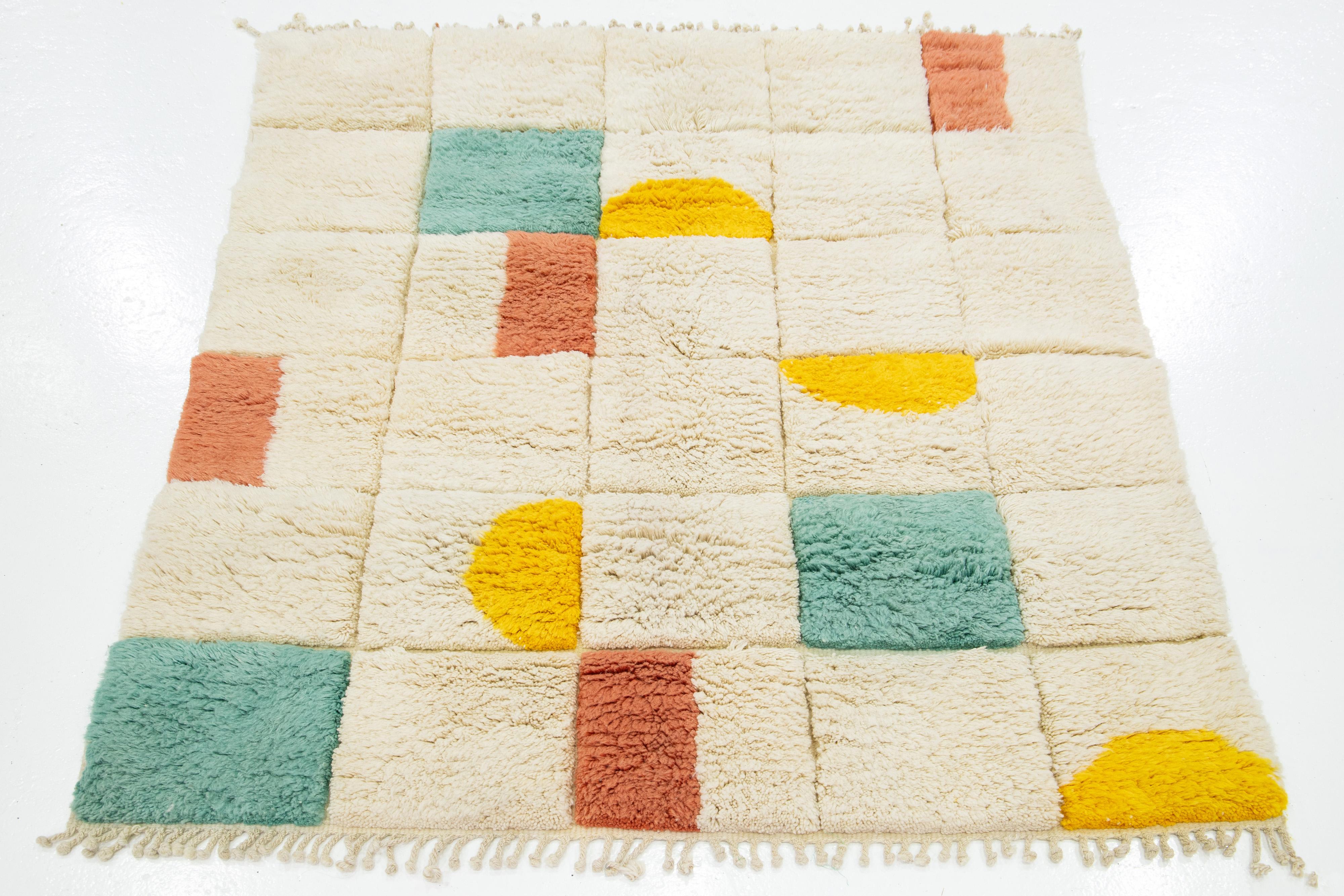 This hand-knotted wool rug features a stunning contemporary Shag Moroccan Style. It has a beautifully geometric abstract design with a beige field. Crafted with the utmost precision, this shag rug is a masterpiece that adds a touch of sophistication