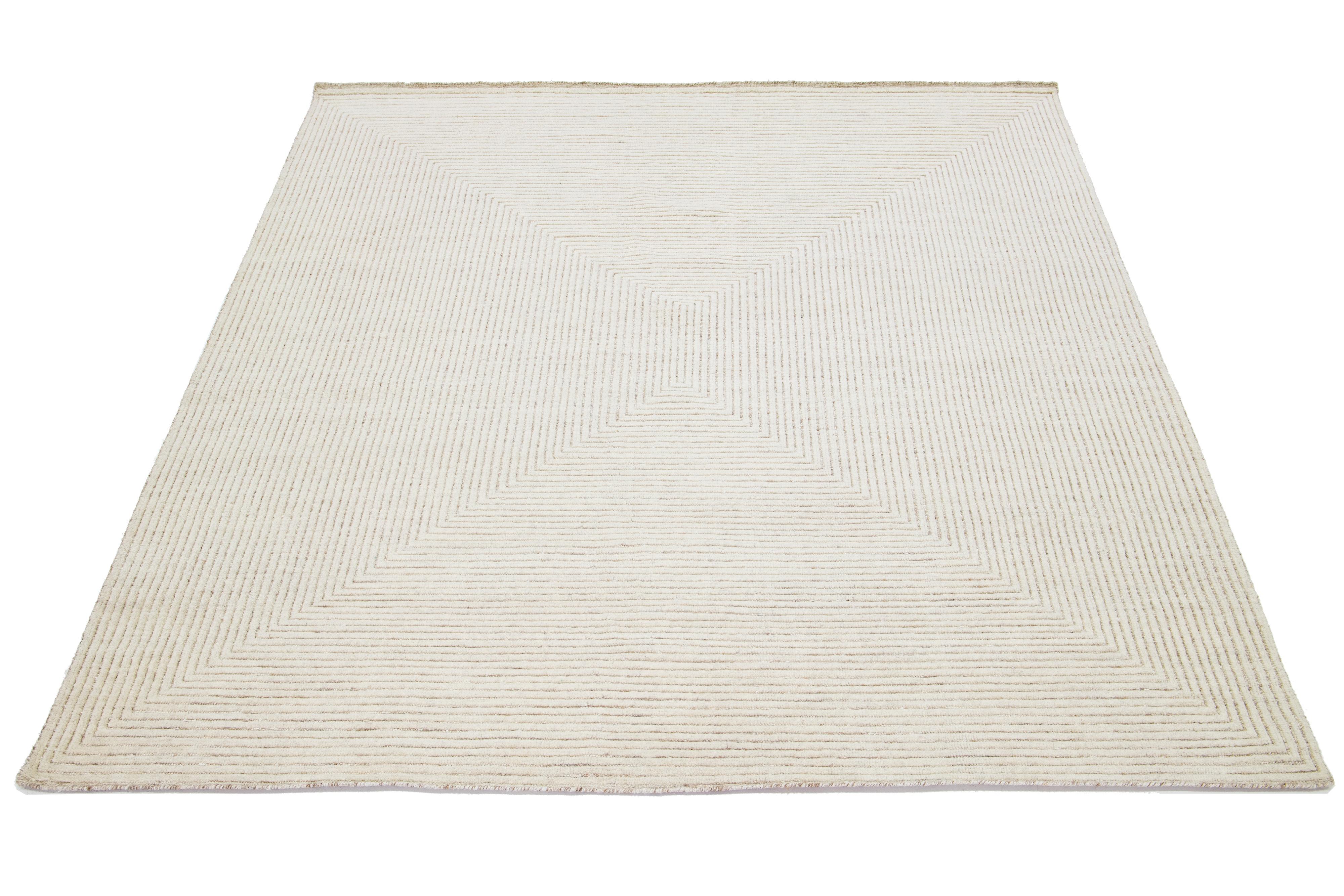 This modern Moroccan rug is hand-knotted from wool and showcases an elegant geometric design in exquisite shades of beige.

This rug measures 7'11