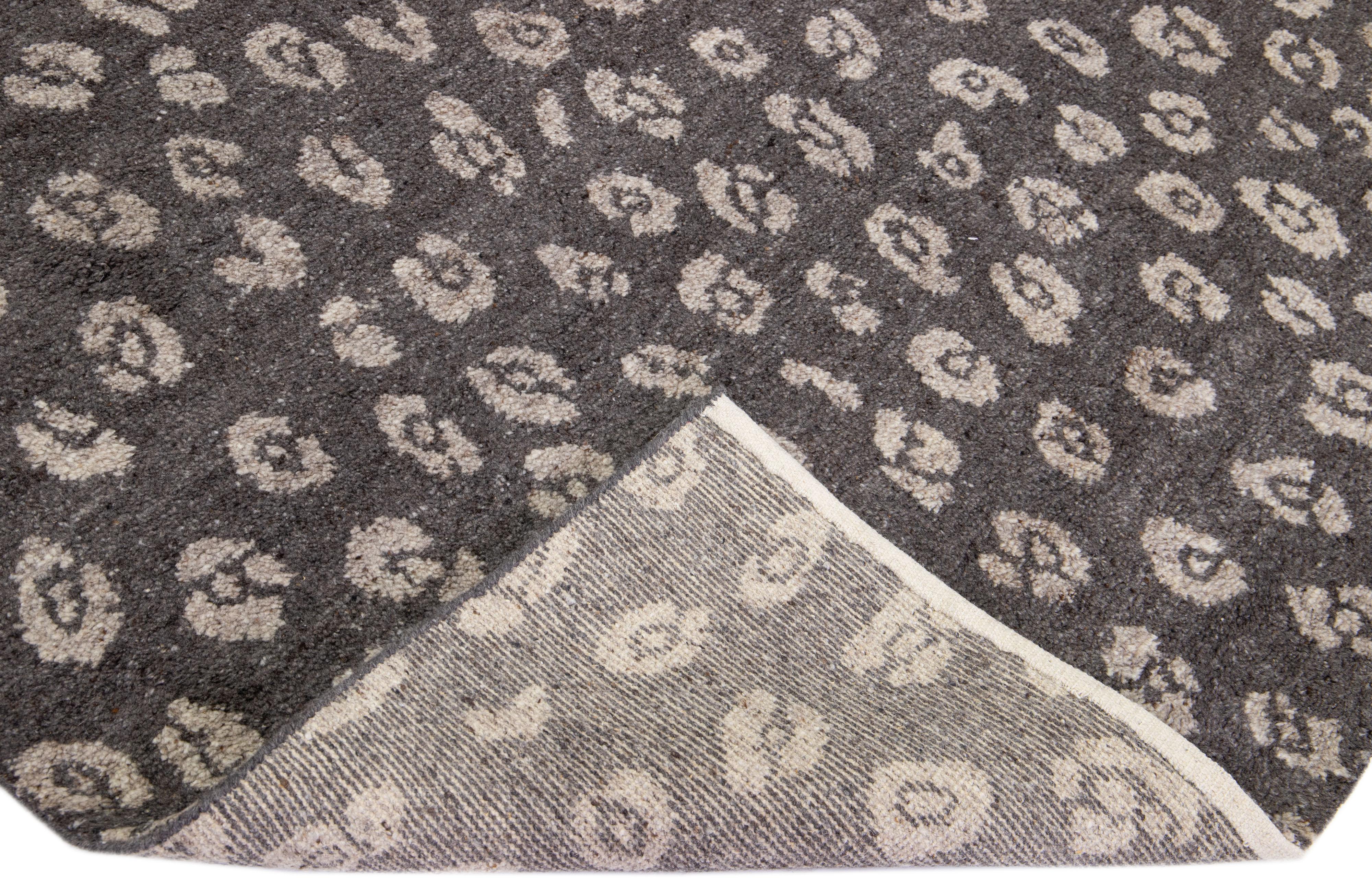 Preciosas alfombras contemporáneas de la colección Thom Filicia Home. Esta alfombra india anudada a mano está hecha de lana y viscosa y tiene un campo gris/carbón y detalles en marfil por todo el diseño. 
El ojo de Thom Filicia para los detalles