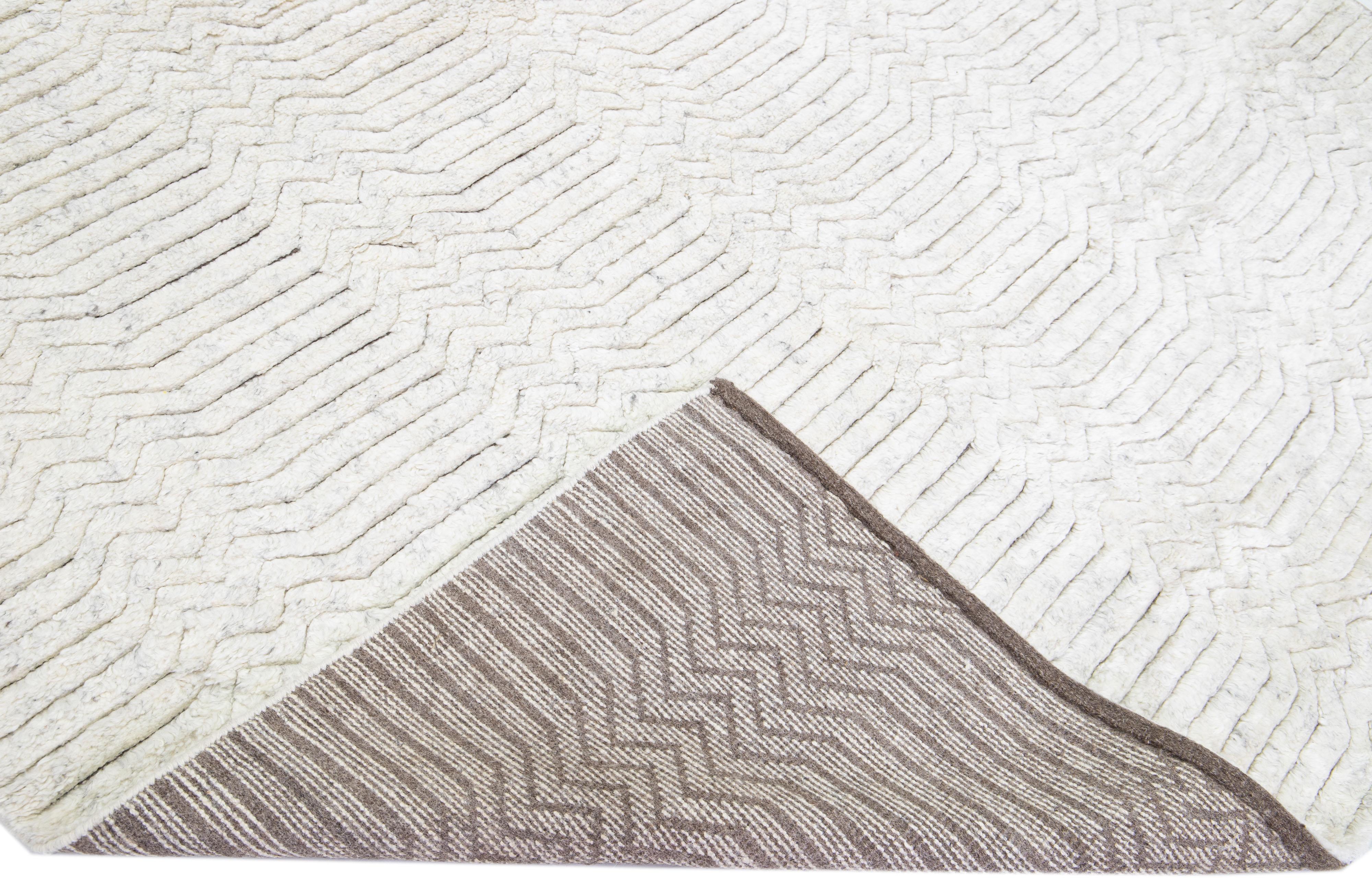 Beautiful Contemporary Thom Filicia Home Collection Rugs. This Indian hand-knotted rug is made of wool & viscose and has a gray field and ivory accents all over the design. 
Thom Filicia´s eye for exquisite detailing and beautiful texture shines
