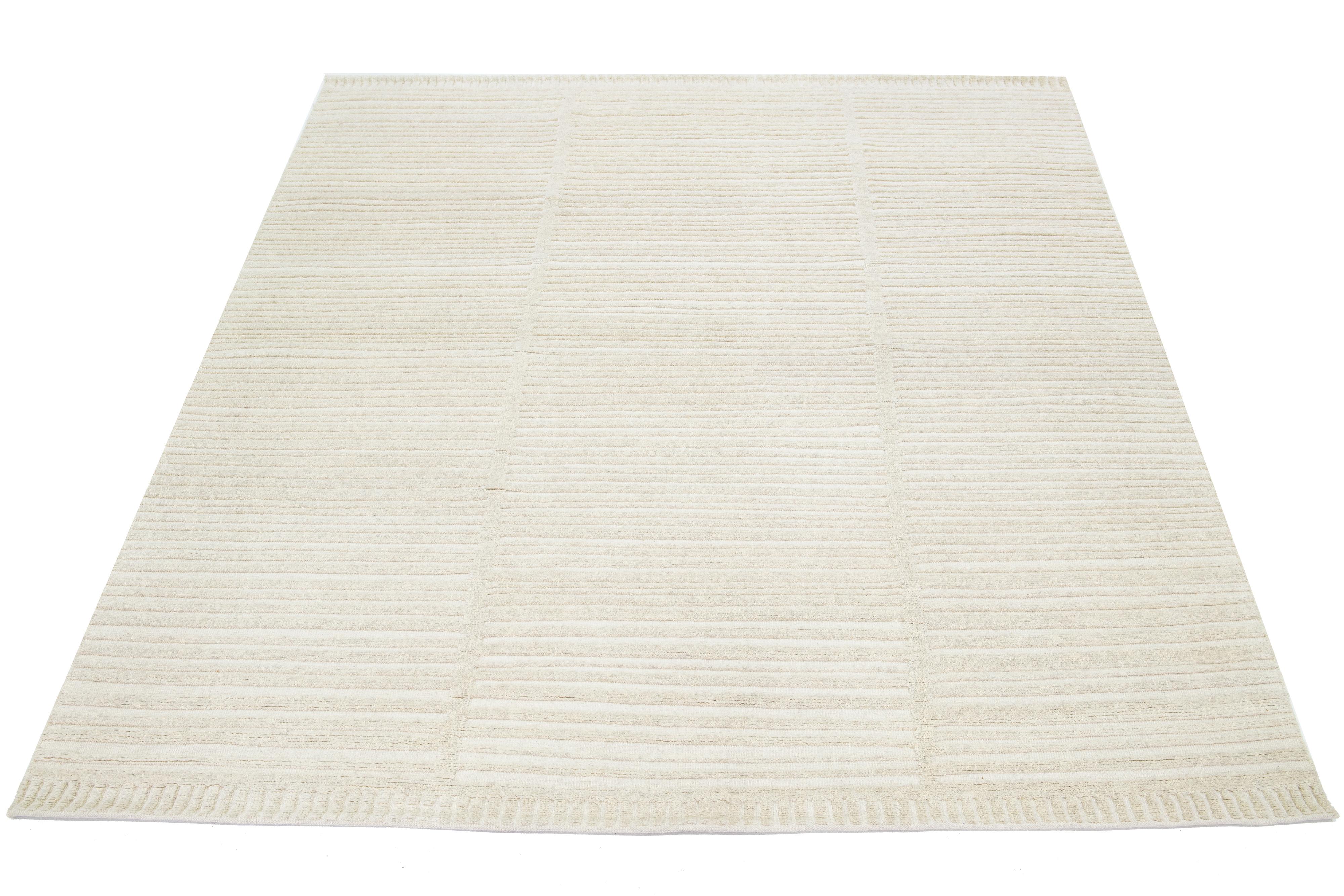 This Moroccan-style wool rug is hand-knotted and showcases a beautiful modern design with a natural ivory field. It features a stunning striped pattern.

This rug measures 8' x 10'.