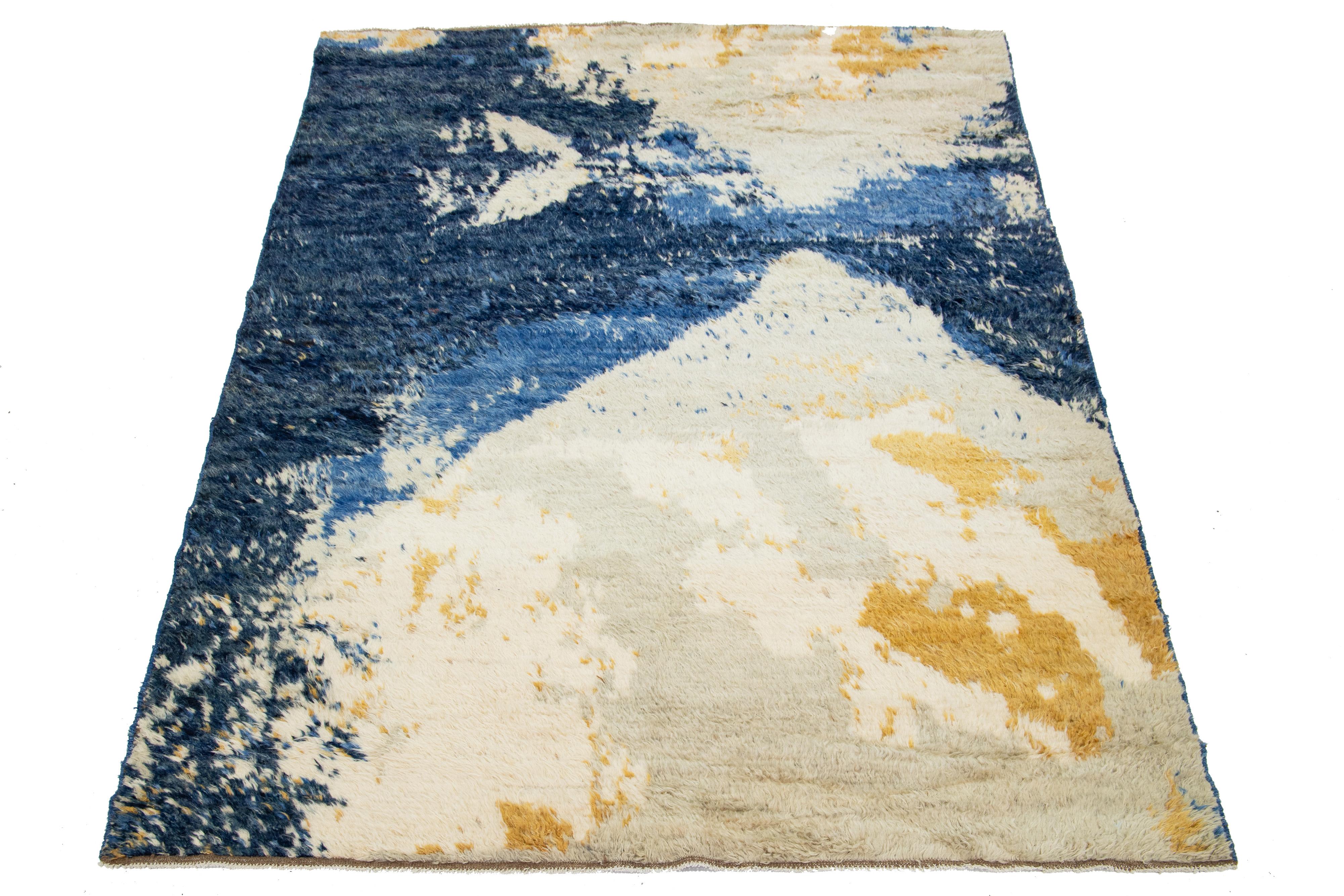 Schöner handgeknüpfter Wollteppich im marokkanischen Stil. Dieser Shag-Teppich hat ein blaues, beiges und goldenes Feld in einem wunderschönen abstrakten Design.

Dieser Teppich misst 6'8