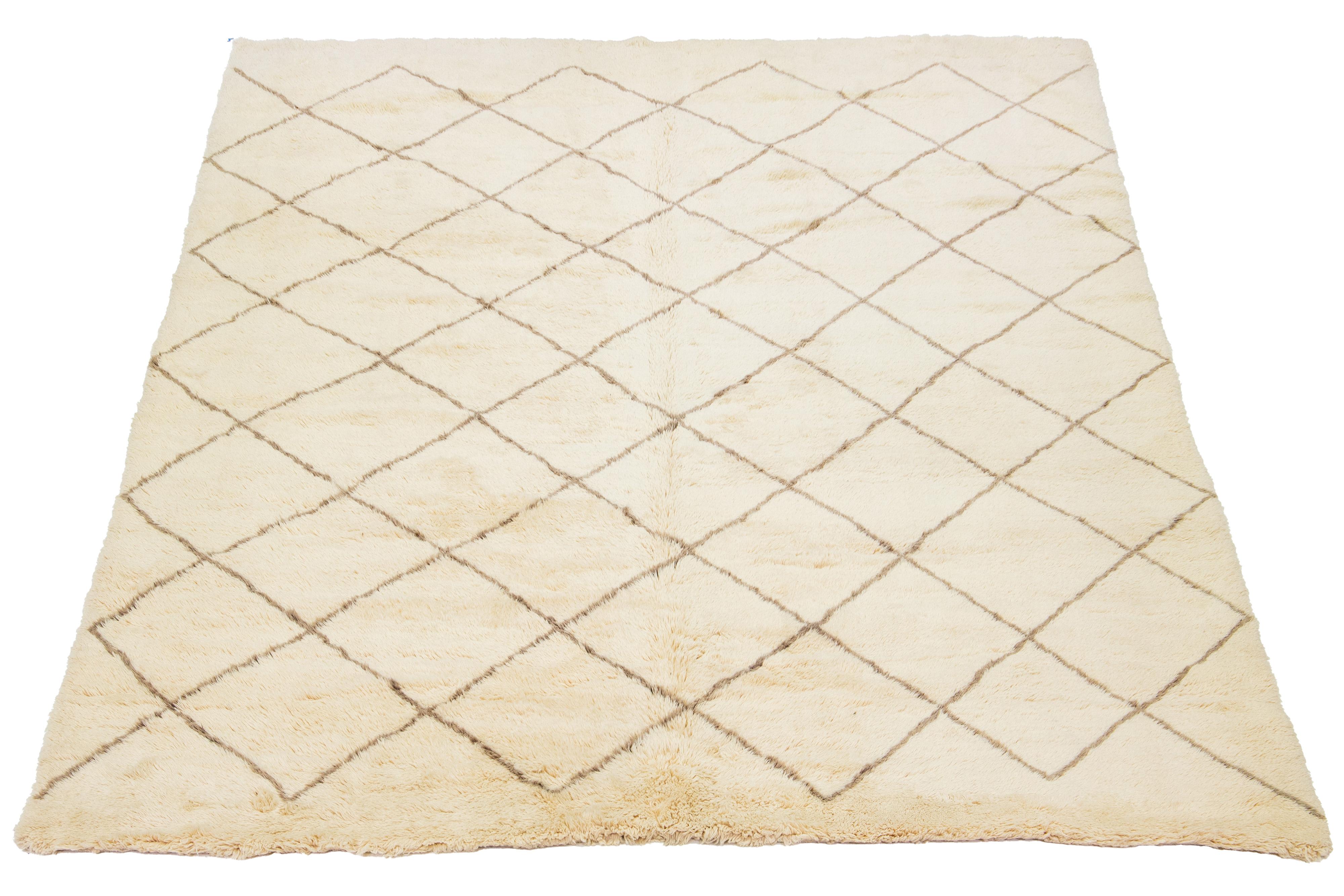 A stunning contemporary Moroccan-style wool rug, meticulously hand-knotted with a beige base and complemented by brown accents in a captivating all-over geometric pattern.

This rug measures 11'1'' x 13'6''.