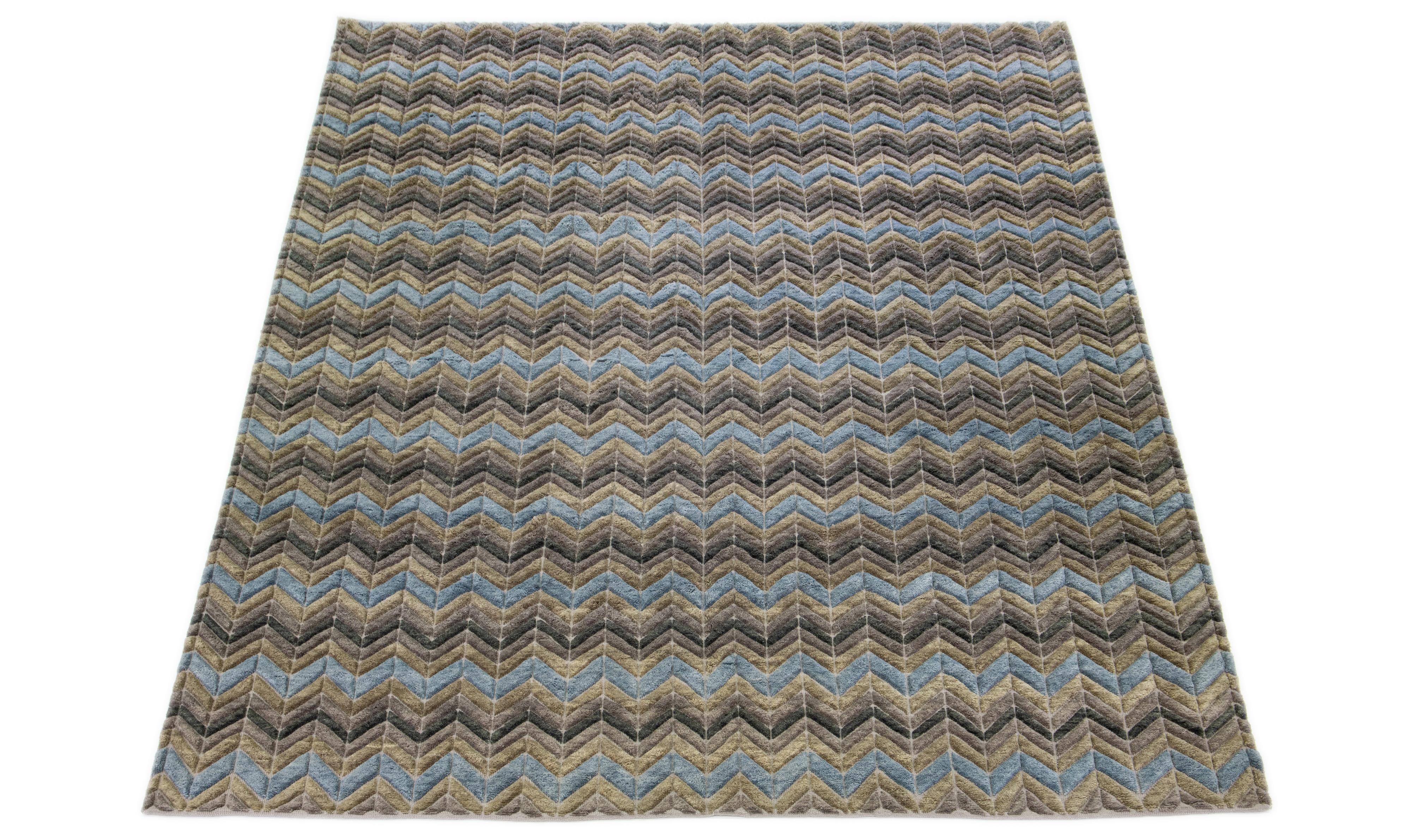 This Modern Moroccan Wool Rug Geometric Motif has an earthy color palette. The rug is meticulously hand-knotted, showcasing a striking geometric Moroccan pattern that adds a contemporary twist. The mixture of earthy shades offers a visual aesthetic