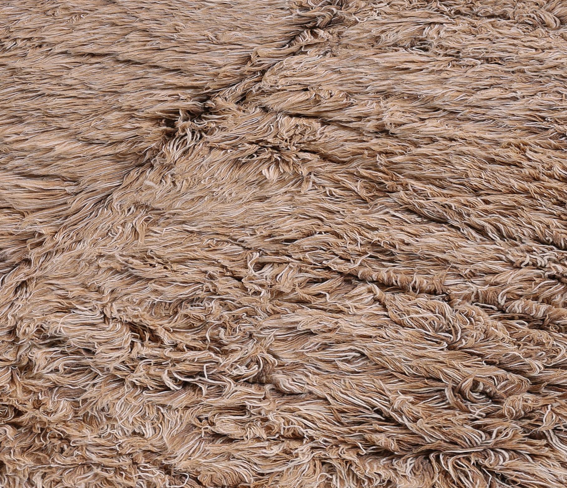 Esta alfombra marroquí contemporánea está anudada a mano con lana 100% de primera calidad por hábiles artesanos de las montañas del Atlas. Con un suave pelo afelpado de tonos naturales y terrosos y sutiles texturas geométricas, aporta calidez y
