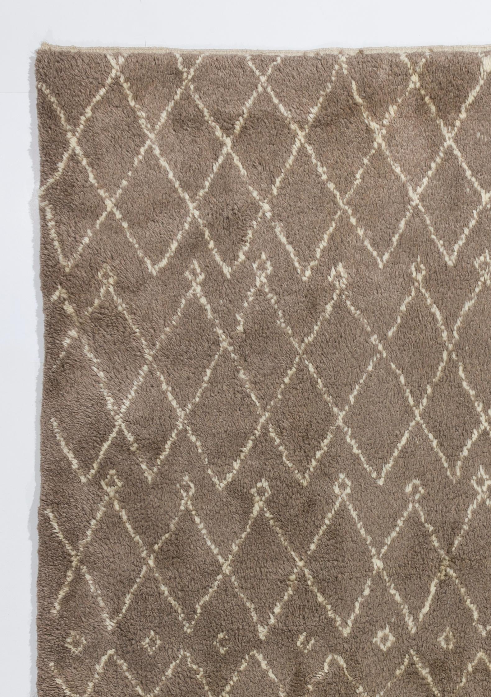 A quietly beautiful Moroccan rug featuring interlocking ivory lozenges on a latte background. Handwoven with soft natural un-dyed lambswool, it has a thick and lush pile. It's soft, subdued colors make a fitting background for Minimalist and modern