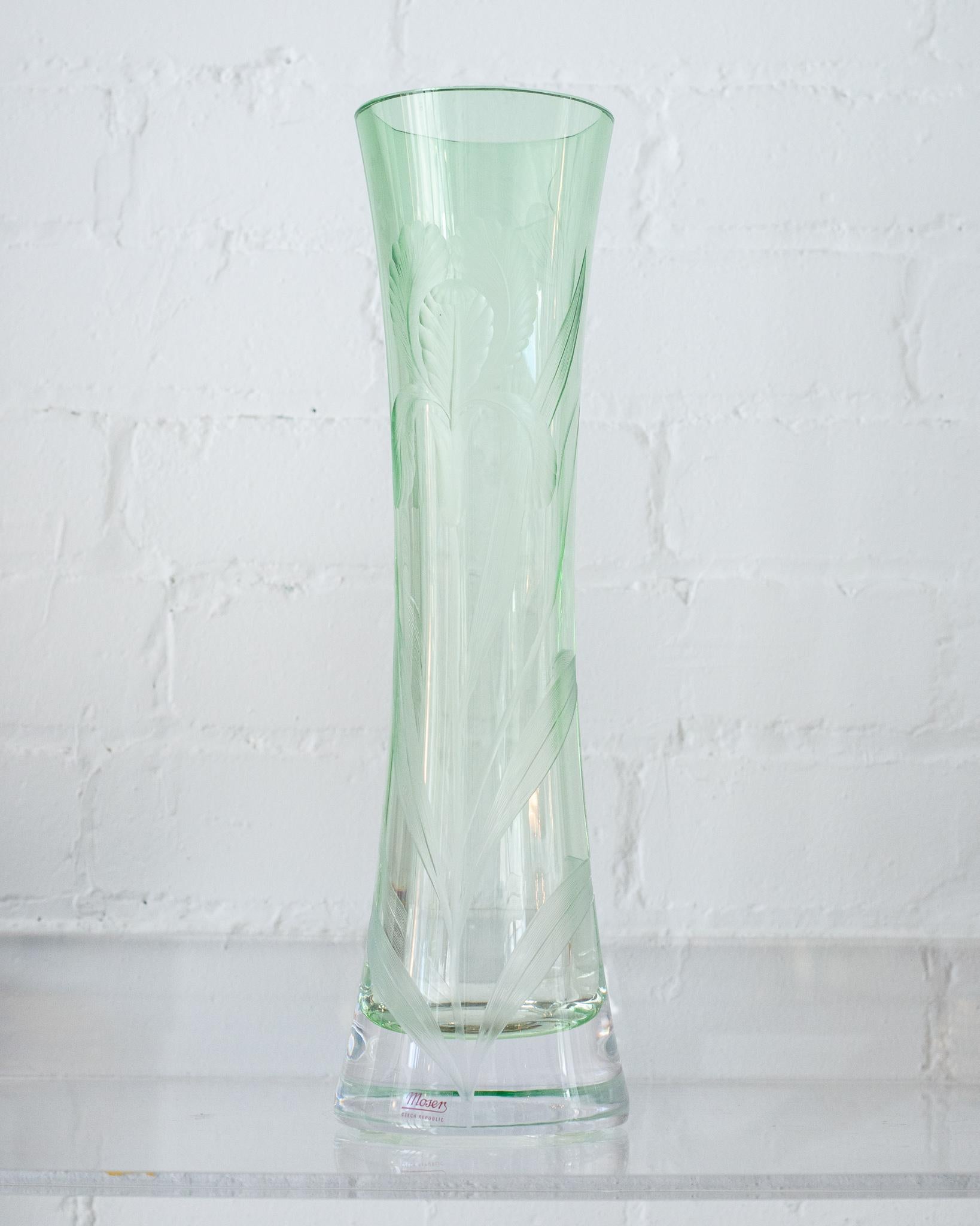 This contemporary green Moser Iris vase is hand blown, handcut, and is the perfect size to hold flowers. A single stem of cymbidium orchids is all it needs. Even empty, it is a stunning accessory with it's soft gradient from clear to green. Signed