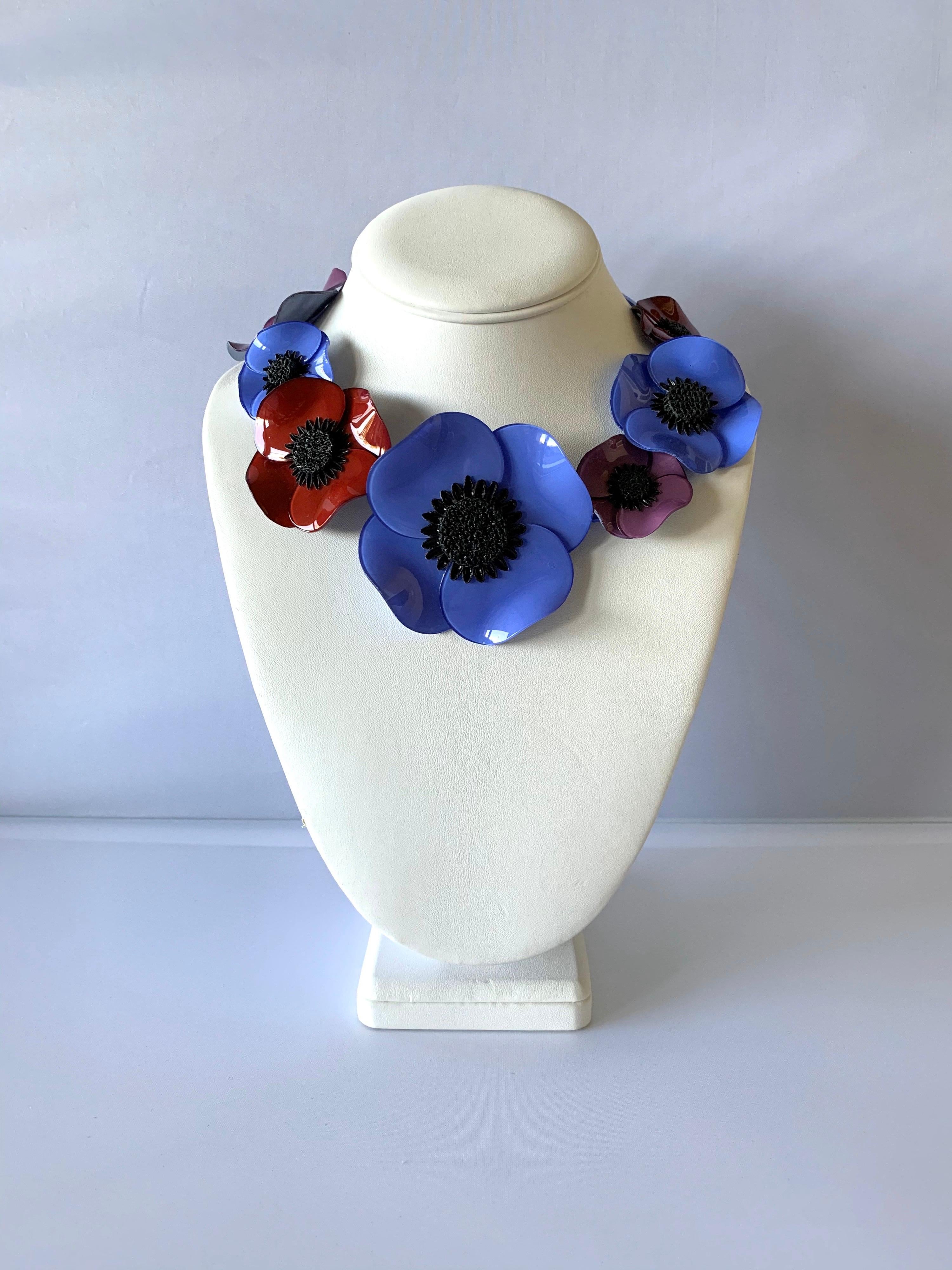 Contemporary handmade adjustable artisanal necklace was made in Paris by Cilea. The statement necklace features seven architectural enameline (enamel and resin composite) poppy flowers in blue, fuchsia, and purple. The poppies differ in size and