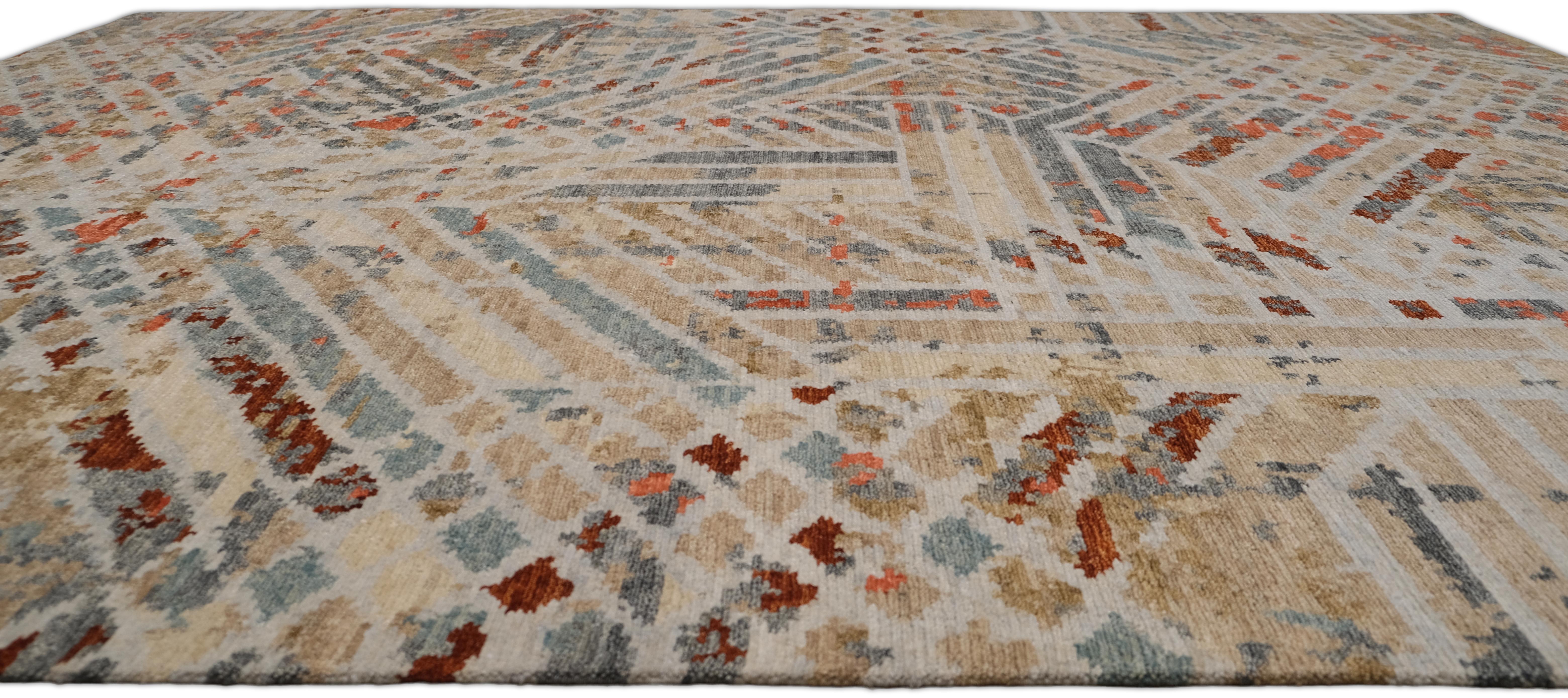 Verschönern Sie Ihren Raum mit der künstlerischen Eleganz dieses handgeknüpften Wollteppichs, der ein kühnes, zeitgenössisches, abstraktes, geometrisches Design in Beige-, Taupe-, Rost- und gedämpften Blautönen zeigt, das Wärme und Raffinesse