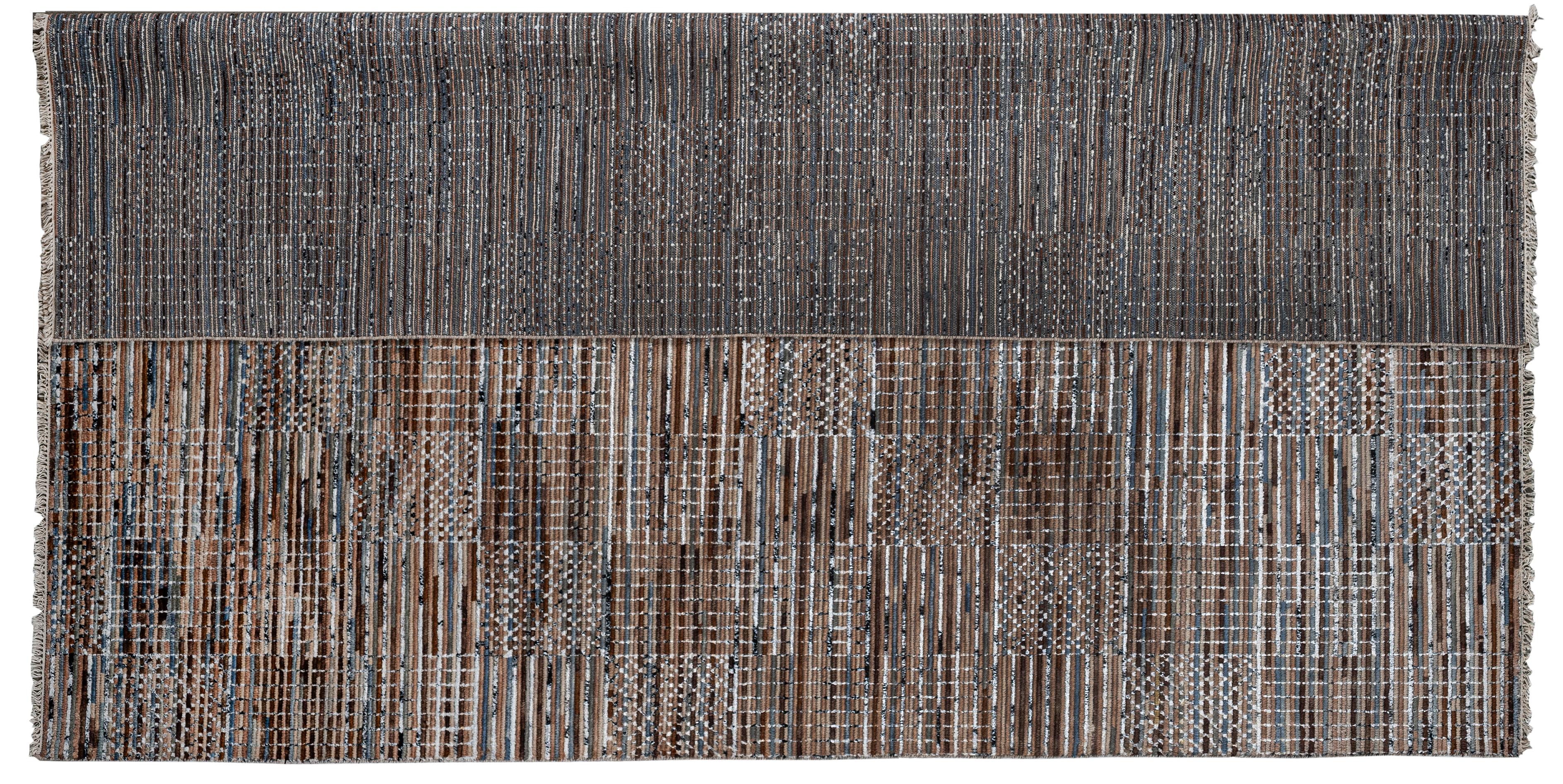 Un mix fresco e contemporaneo di colori e motivi si combina per creare una rivisitazione moderna del tappeto patchwork. I toni caldi del marrone e dell'abbronzatura contrastano con quelli freddi dell'argento/grigio e del bianco, rendendo l'opera
