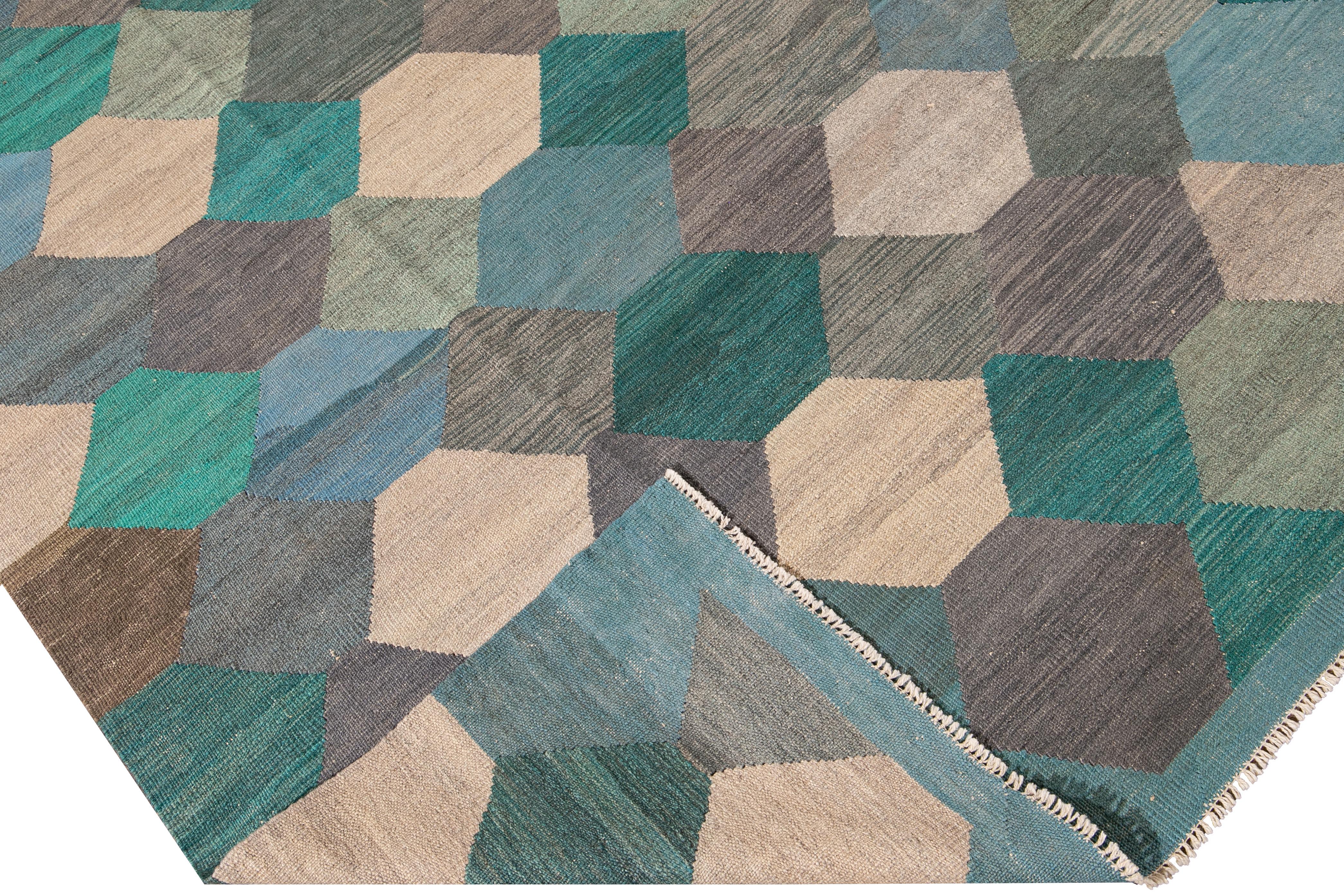 Beautiful modern Kilim flat-weave wool rug. This kilim rug has a green, beige, blue, and gray field in a gorgeous geometric hexagon pattern design.

This rug measures: 8'2