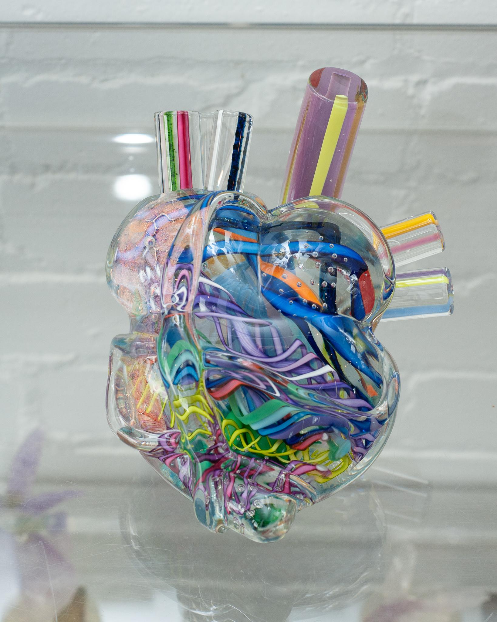 A stunning and unique decorative and blown glass anatomical heart sculpture in multicolour by a Canadian artist. A one of kind work of glass art, this sculpture features multiple depths of colour and iridescence.