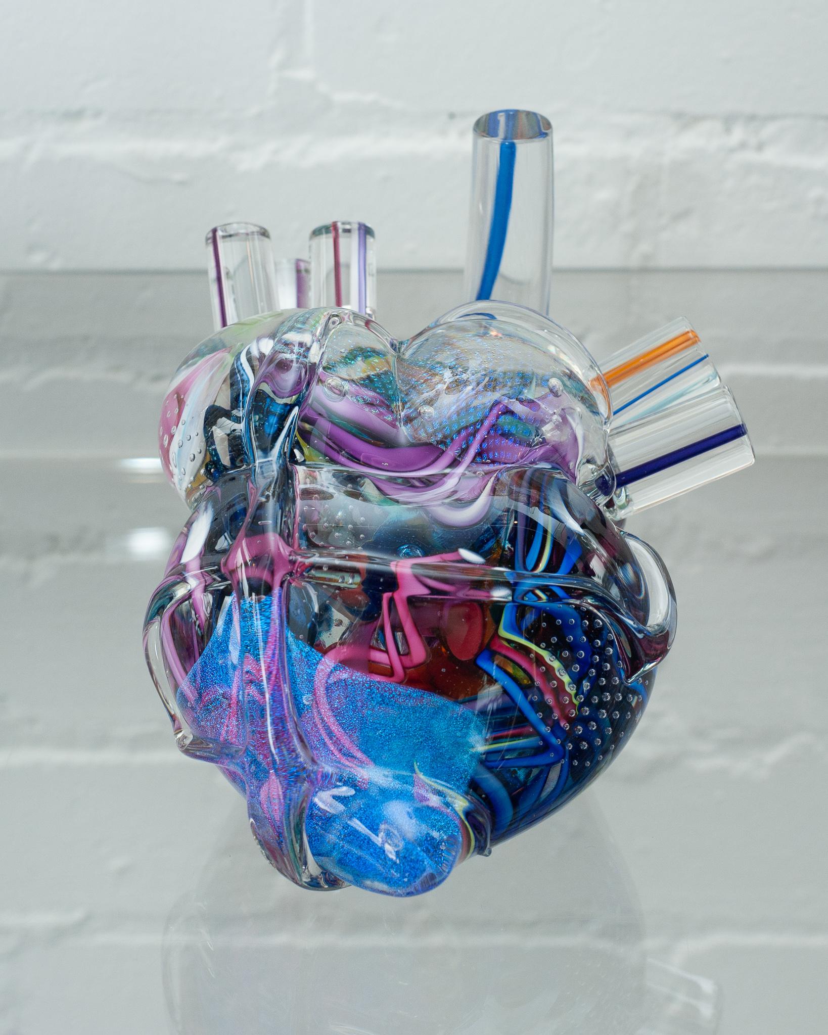 A stunning and unique decorative and blown glass anatomical heart sculpture in multicolour by a Canadian artist. A one of kind work of glass art, this sculpture features multiple depths of colour and iridescence.