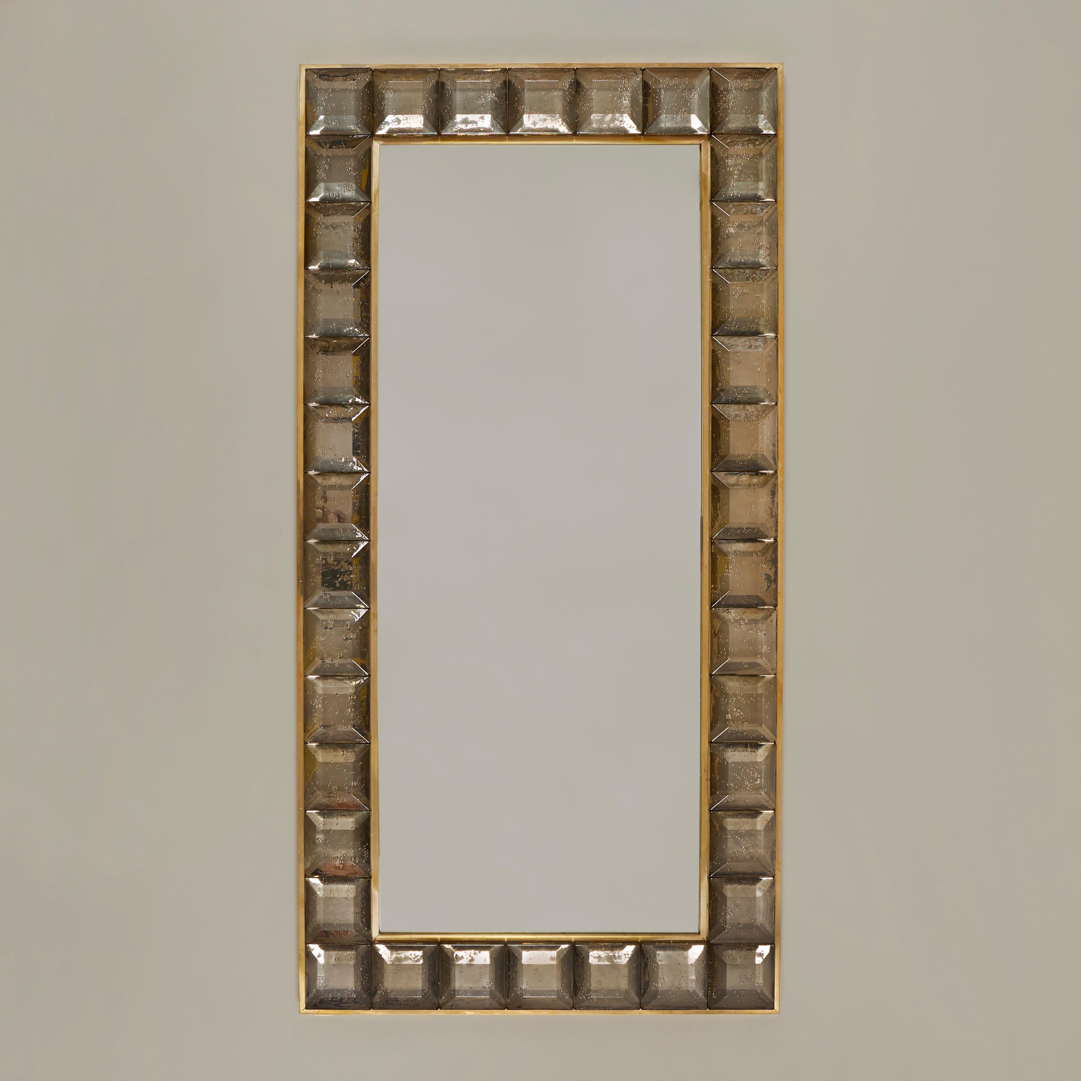 Stunning contemporary Italian rectangular mirror surrounded with 38 faceted Murano glass 'jewels' in a soft brown fume shade. The design incorporates a chic brass decorative edge to both the mirror and outer frame of the glass. The overall effect is