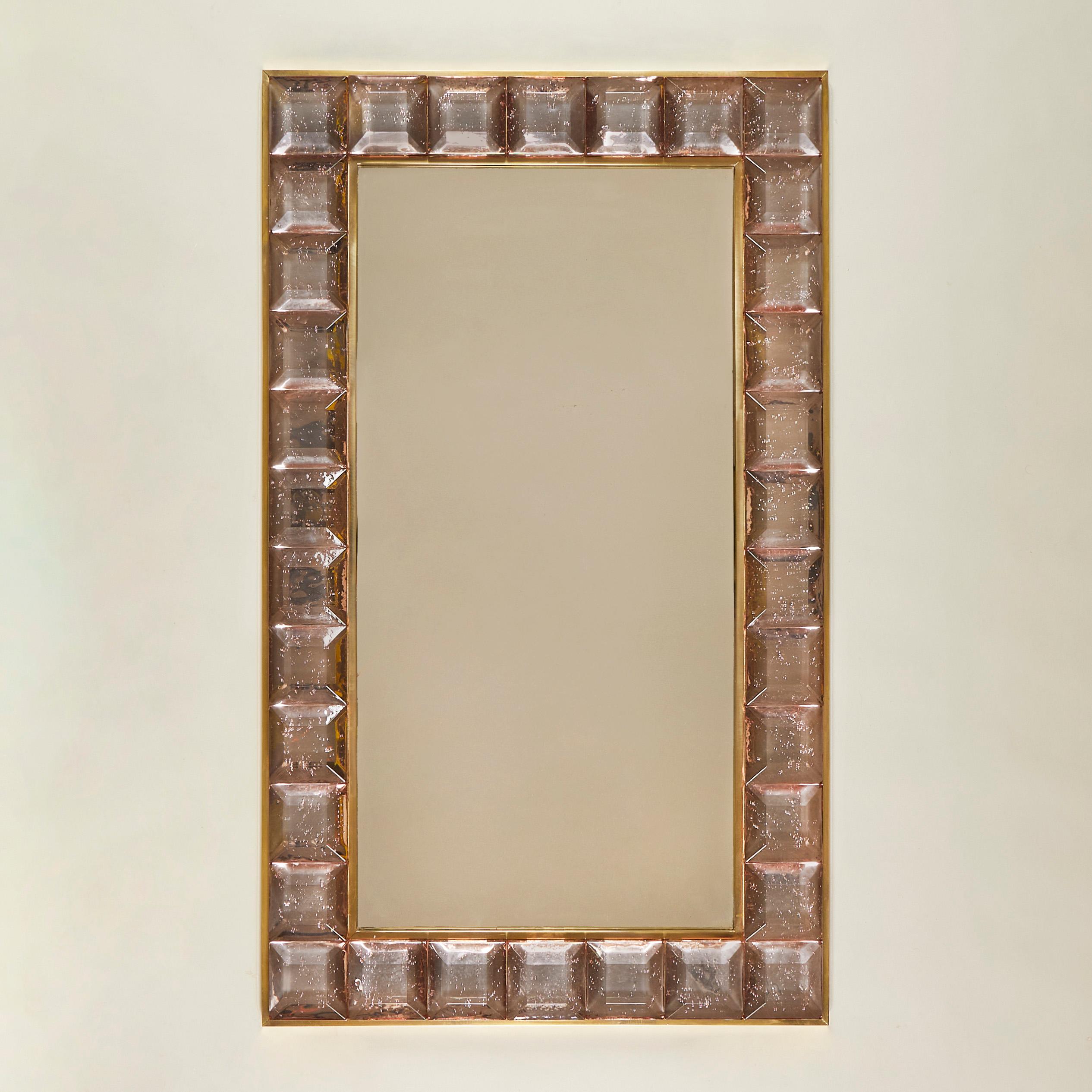 Stunning contemporary Italian rectangular mirror surrounded with 34 faceted Murano glass 'jewels' in soft shade of pale pink. The design incorporates a chic brass decorative edge to both the mirror and outer frame of the glass. The overall effect is
