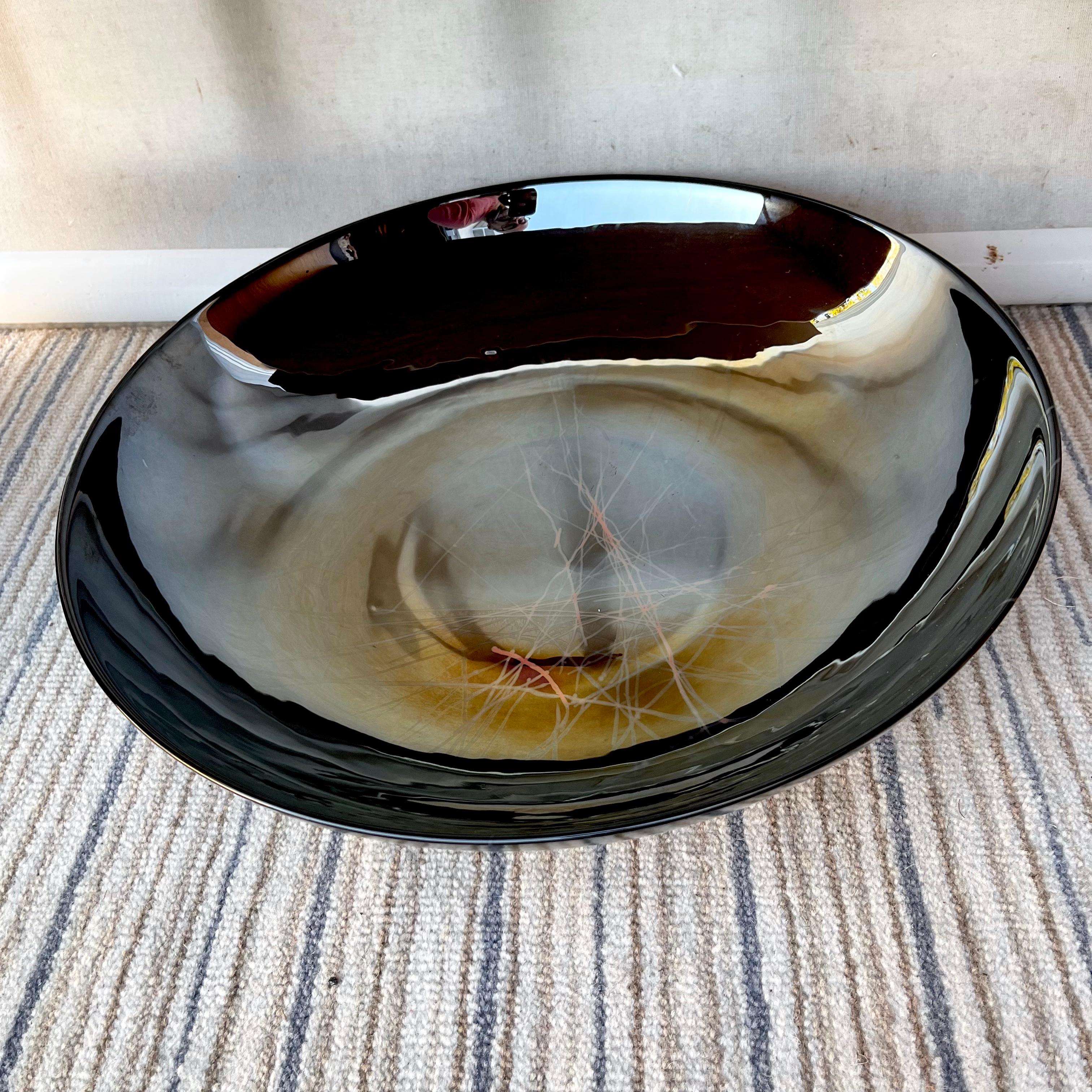 Large Contemporary Murano glass centerpiece decorative bowl by Yalos Casa Murano. Circa Early 2000s. 
Features a muted black exterior shell with a polished pearl like light reflecting opalescent glass interior surfaced in a dark pewter color,