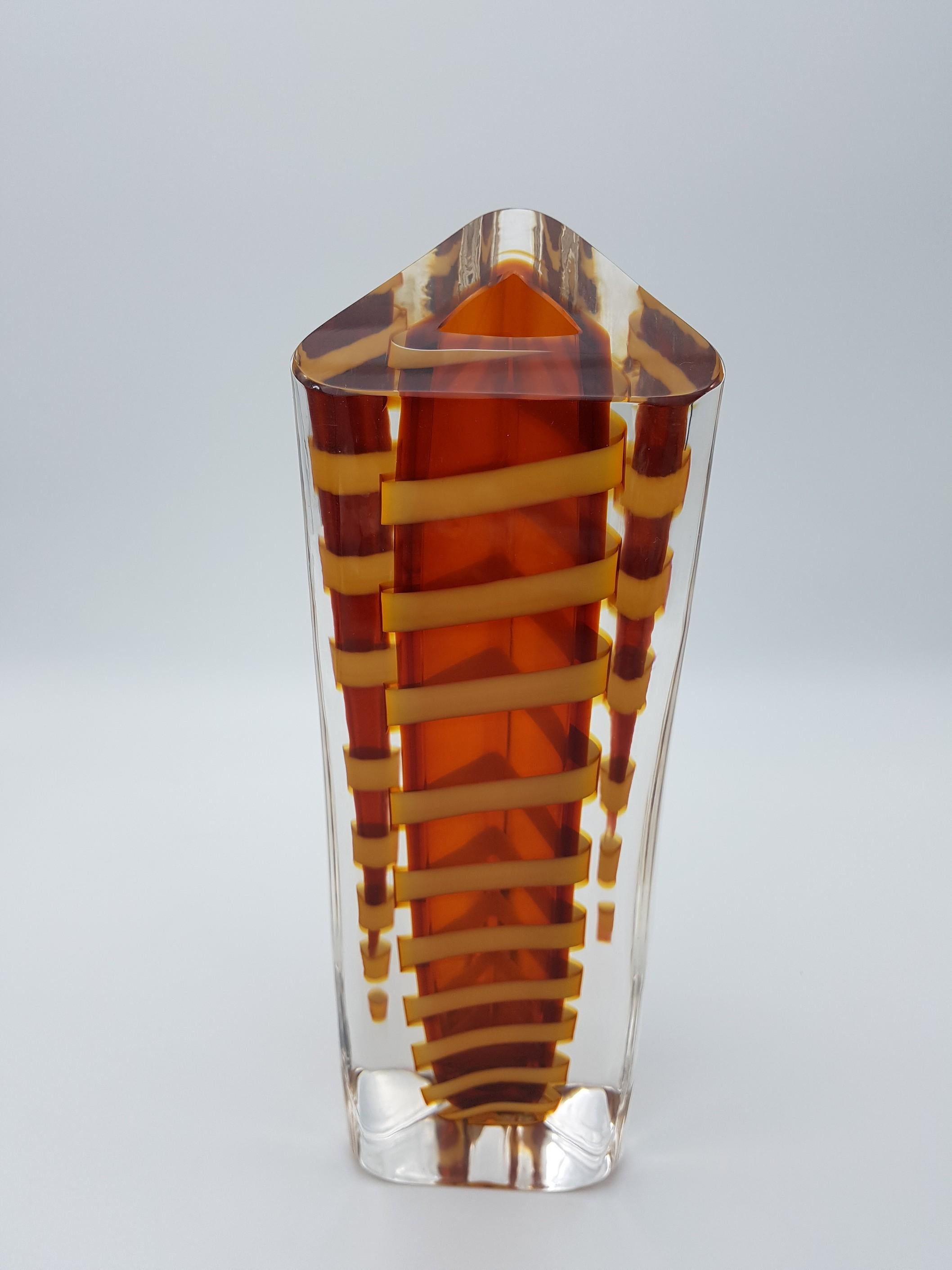 Murano glass solid vase by Gino Cenedese e Filgio, with thick walls and triangular cross section. The warm amber color of this vase is highlighted by a pairing yellow spiral. The geometry and dynamism in this vase is impressive: the spiralling motif