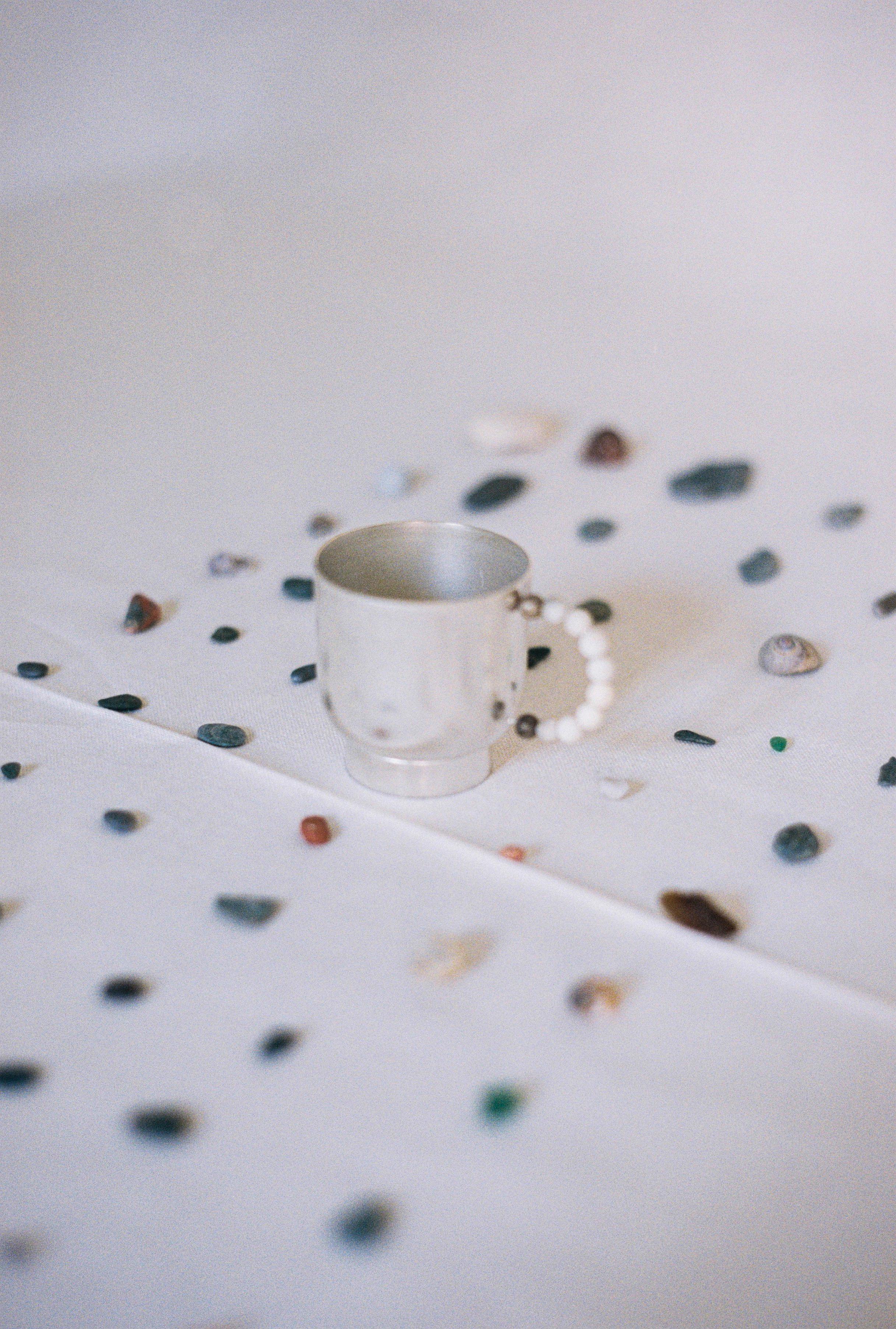 Elevate your daily tea or coffee ritual with our  perlina cup and piattino. The plated brass cup and plate are handcrafted in Italy using sheet turning techniques. The handle, adorned with a row of lapiz lazuli  or white stones, introduces a touch