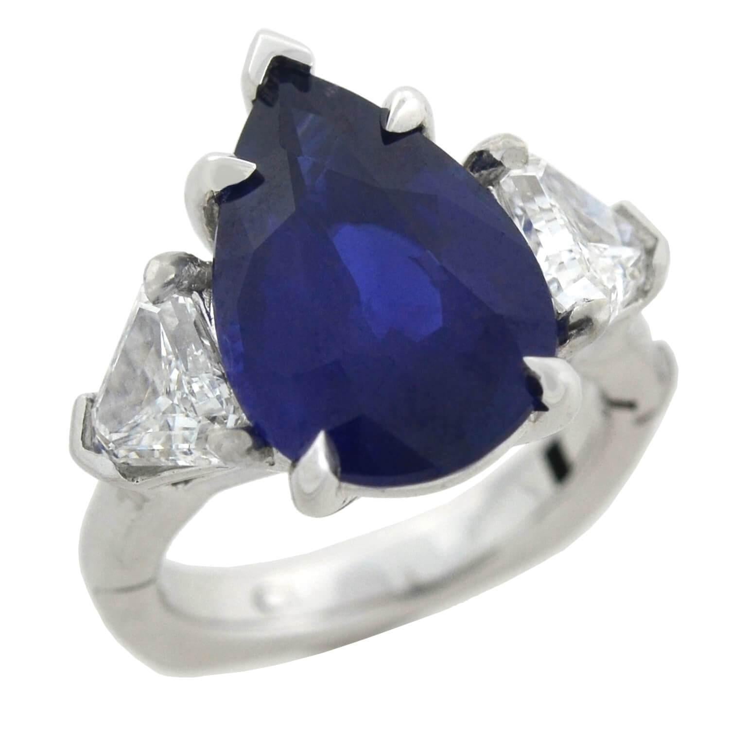 An incredible and unique Estate sapphire and diamond ring! This stunning 14kt white gold piece holds an impressive 6.05ct Pear shaped natural heated sapphire at the center of a gorgeous diamond setting. The vivid stone is claw set, exhibiting