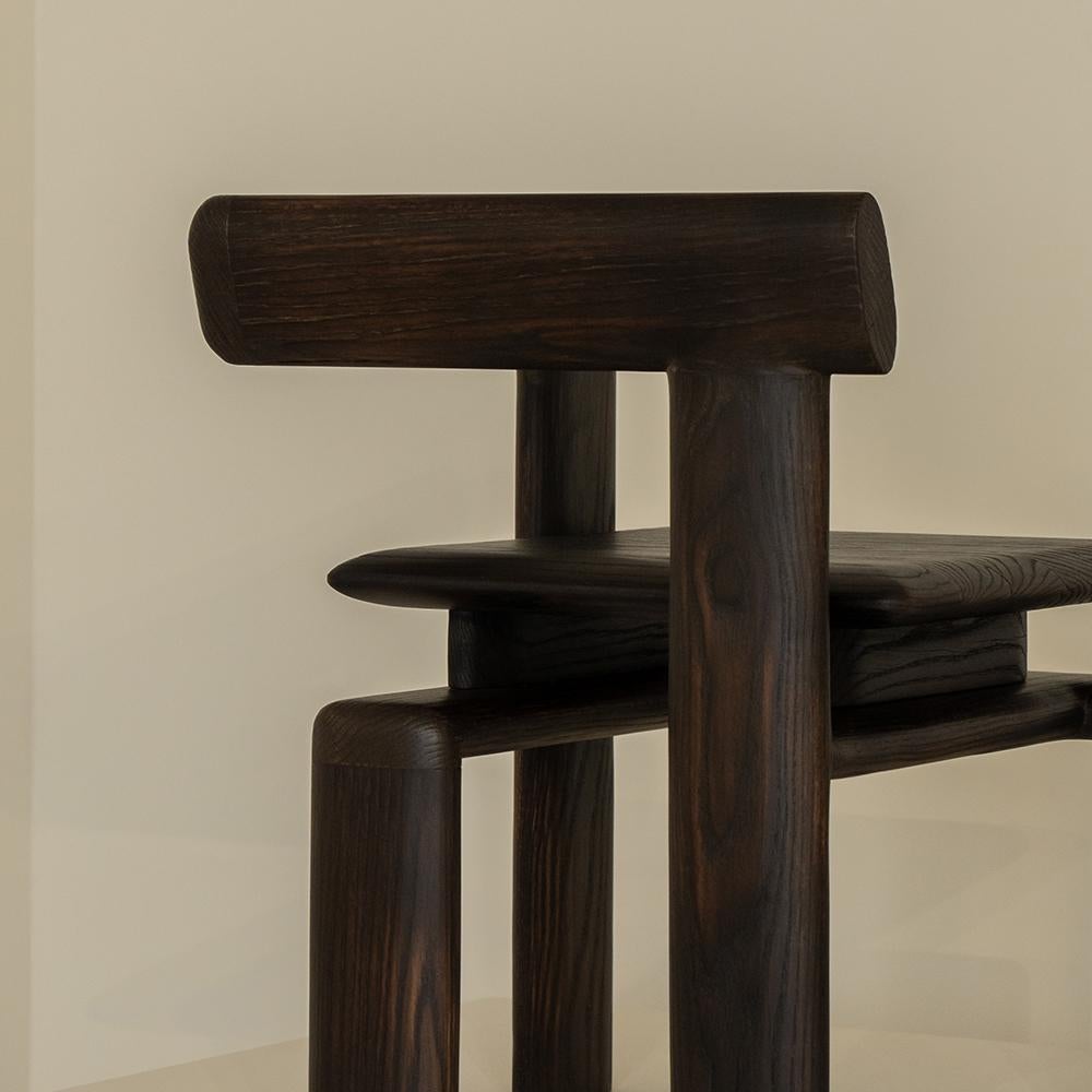 The Nelligan chair emerges as an unfinished structure, rooted within the internal confines of the solidity of a cube. This latter, envisioned as the epitome of stability, stands in stark contrast with its clearly defined boundaries, thus revealing