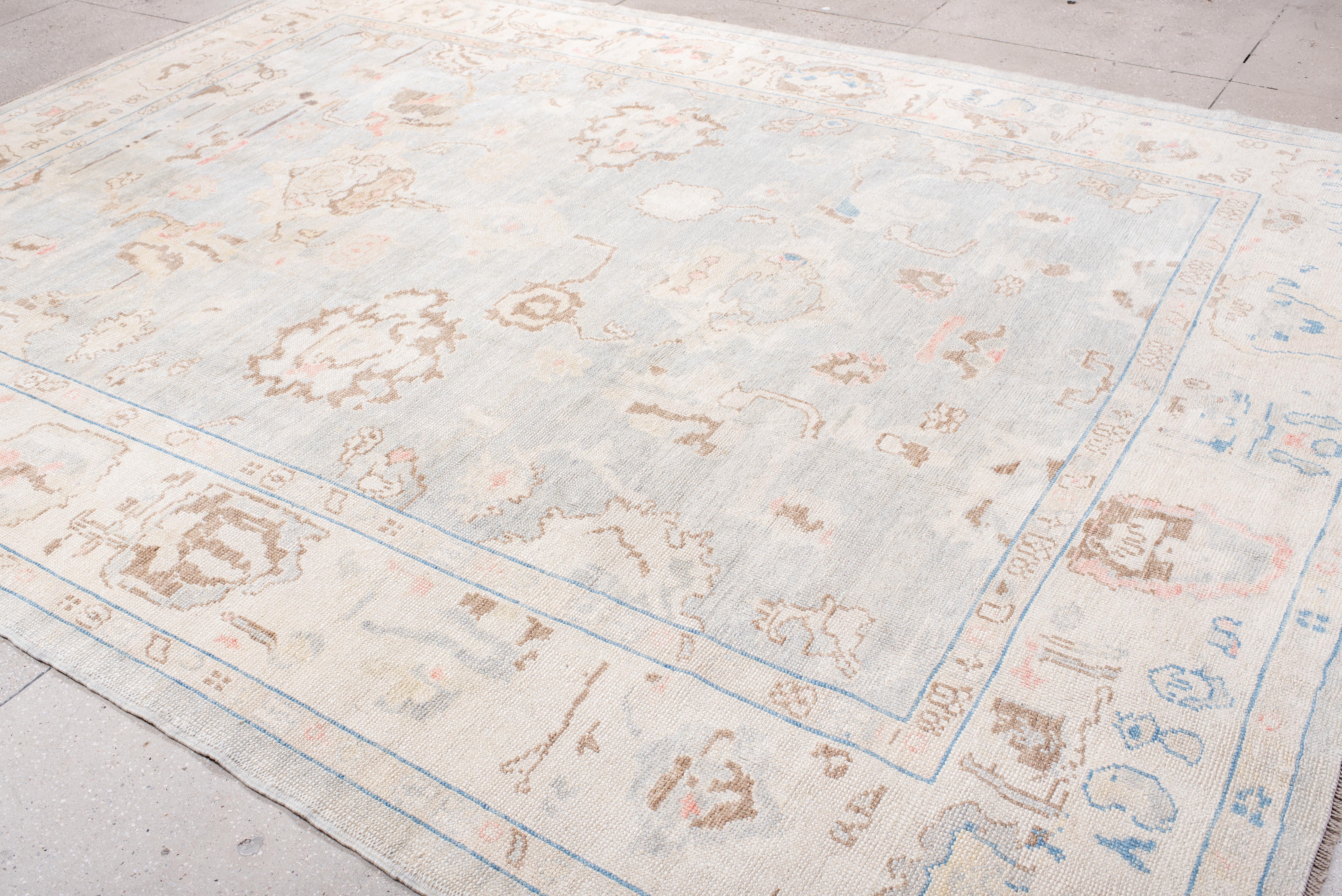 Esta alfombra Oushak, una tranquila declaración de refinamiento, se define por su delicada interacción de motivos tradicionales y espacios abiertos. El diseño suavemente descolorido le confiere una elegancia desgastada y sin esfuerzo, mientras que