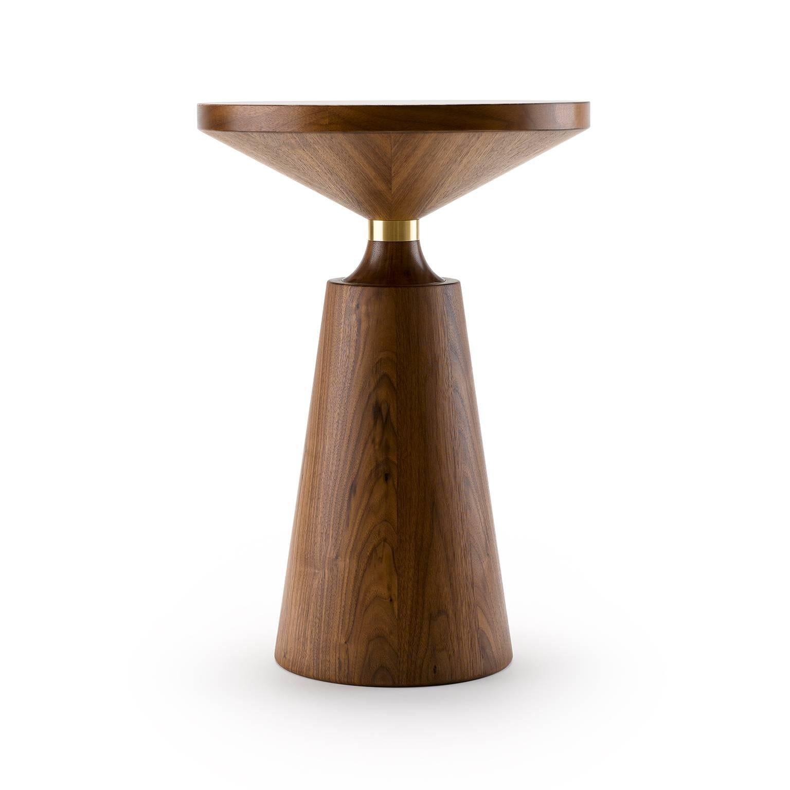 Turned by hand and using both solid and veneered timber, the Nicole Side Table has a simple but graphically striking Silhouette punctuated by the metal collar. The Nicole Side Table is shown here in natural oiled walnut with natural brass (front)