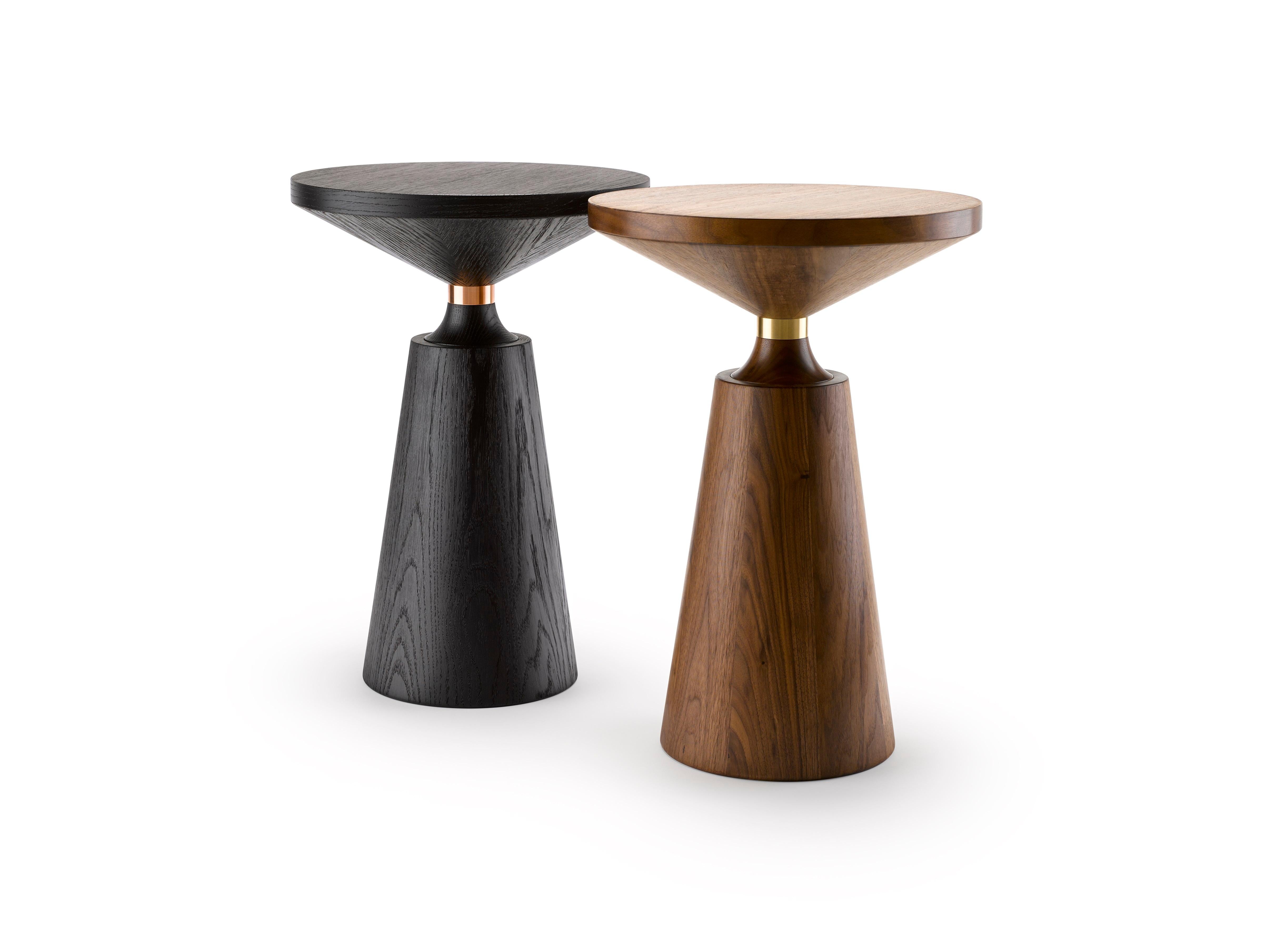 Turned by hand and using both solid and veneered timber, the Nicole Side Table has a simple but graphically striking Silhouette punctuated by the metal collar. Shown here in oiled walnut and brass (main) and also in black lacquered walnut and
