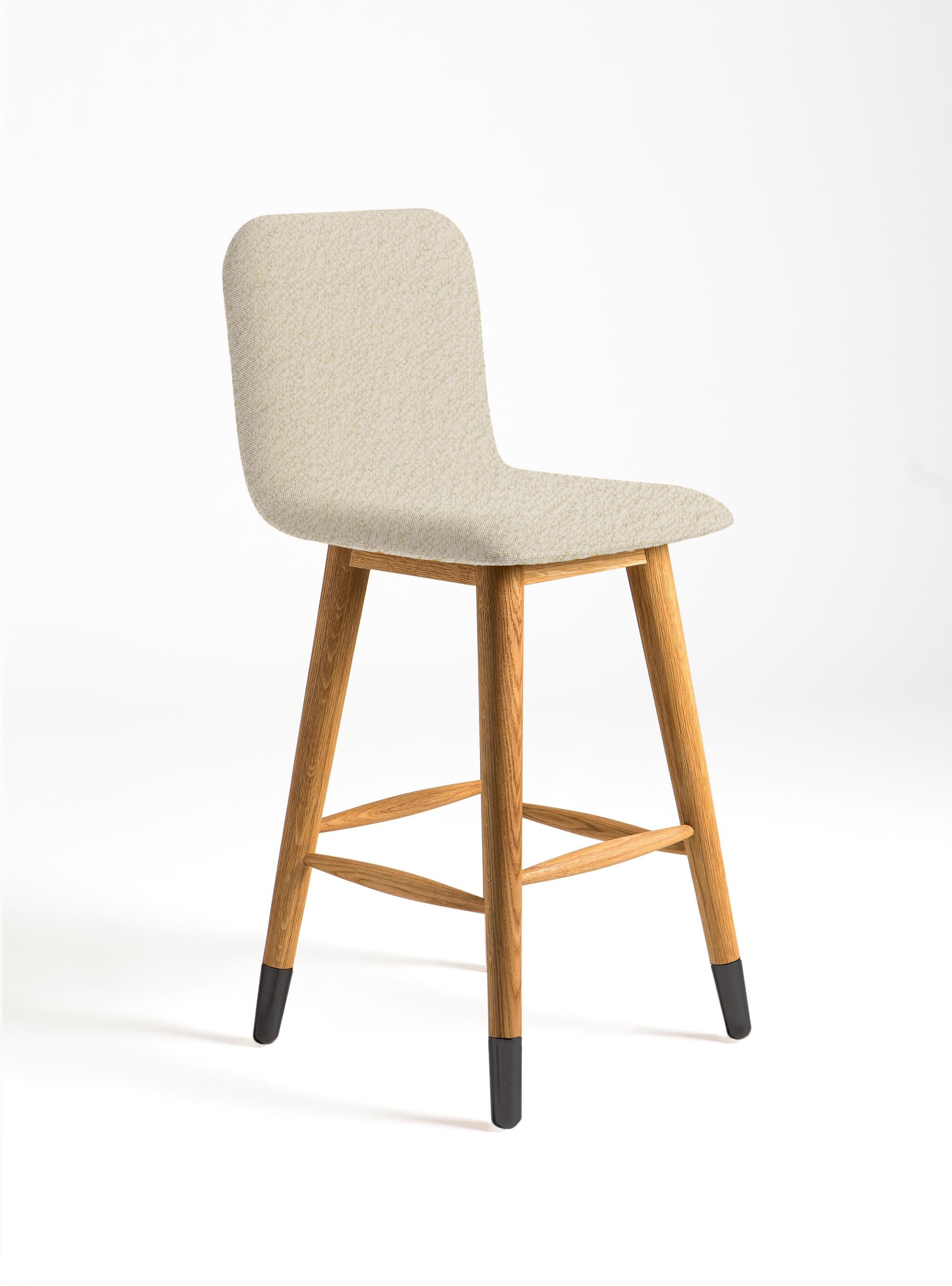 Mistral bar stool is designed to bring fresh, modern, natural style to its environment. Black polished metal and American white oak legs are combined with elegant white boucle fabric.