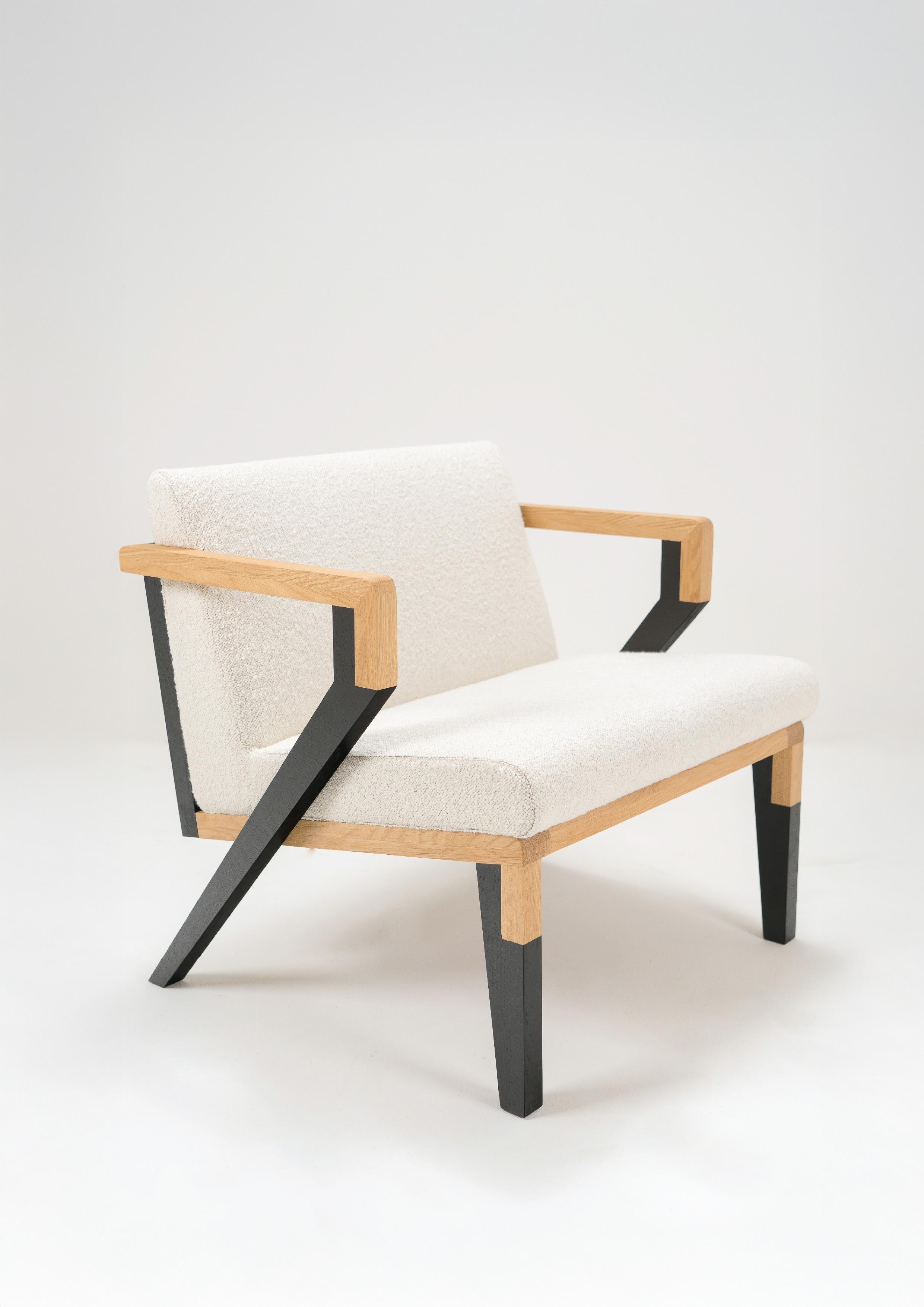 The Oillin model is defined by its striking geometric lines, mixing natural oak with lacquered wood in a sculptural silhouette that commands attention from every angle.

Crafted from solid oak, the frame features a dynamic contrast between warm wood