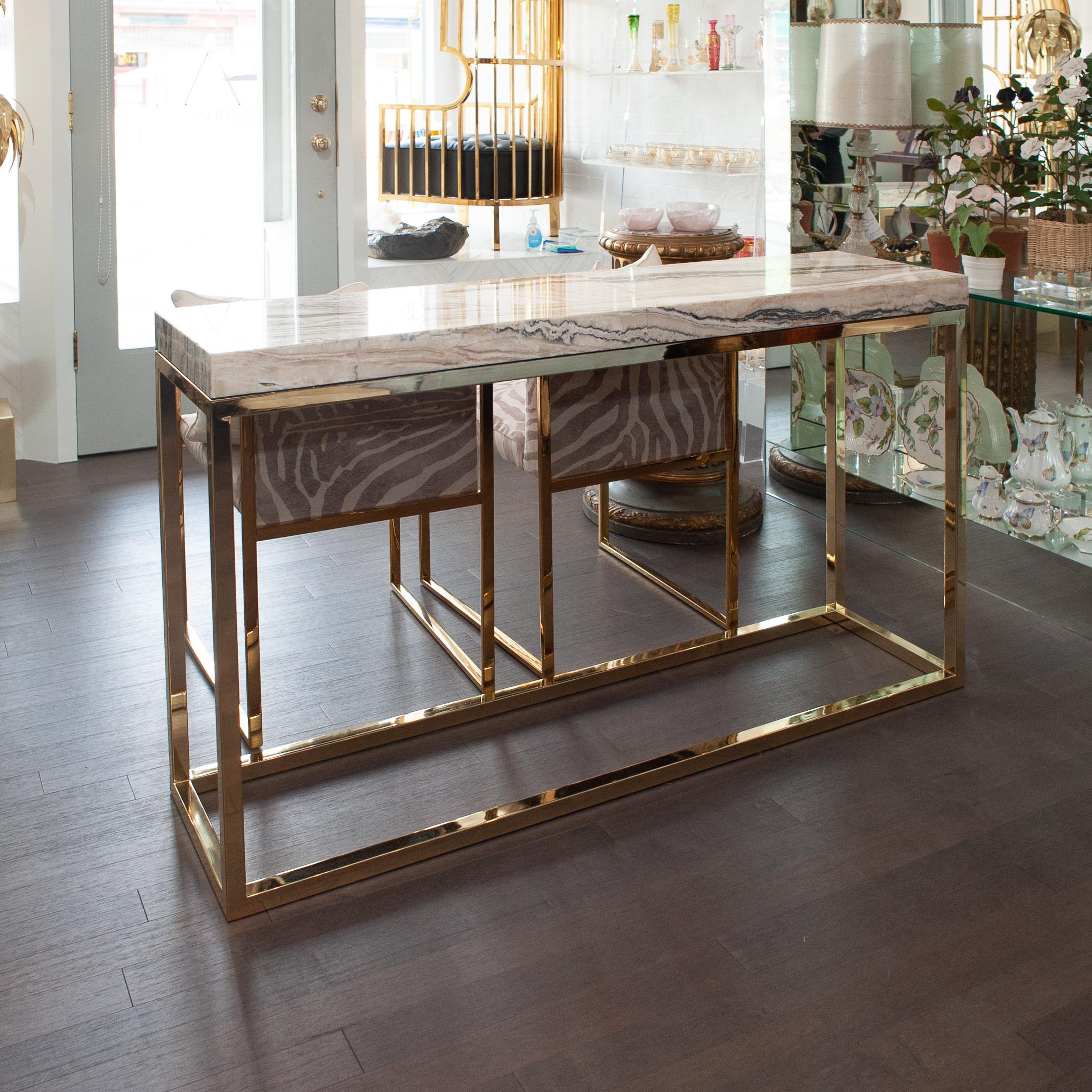 A gorgeous console table with polished brass base and thick onyx top. The perfect entryway piece with a Mid Century Modern flair. The combination of polished brass and natural onyx stone is always timeless and chic.