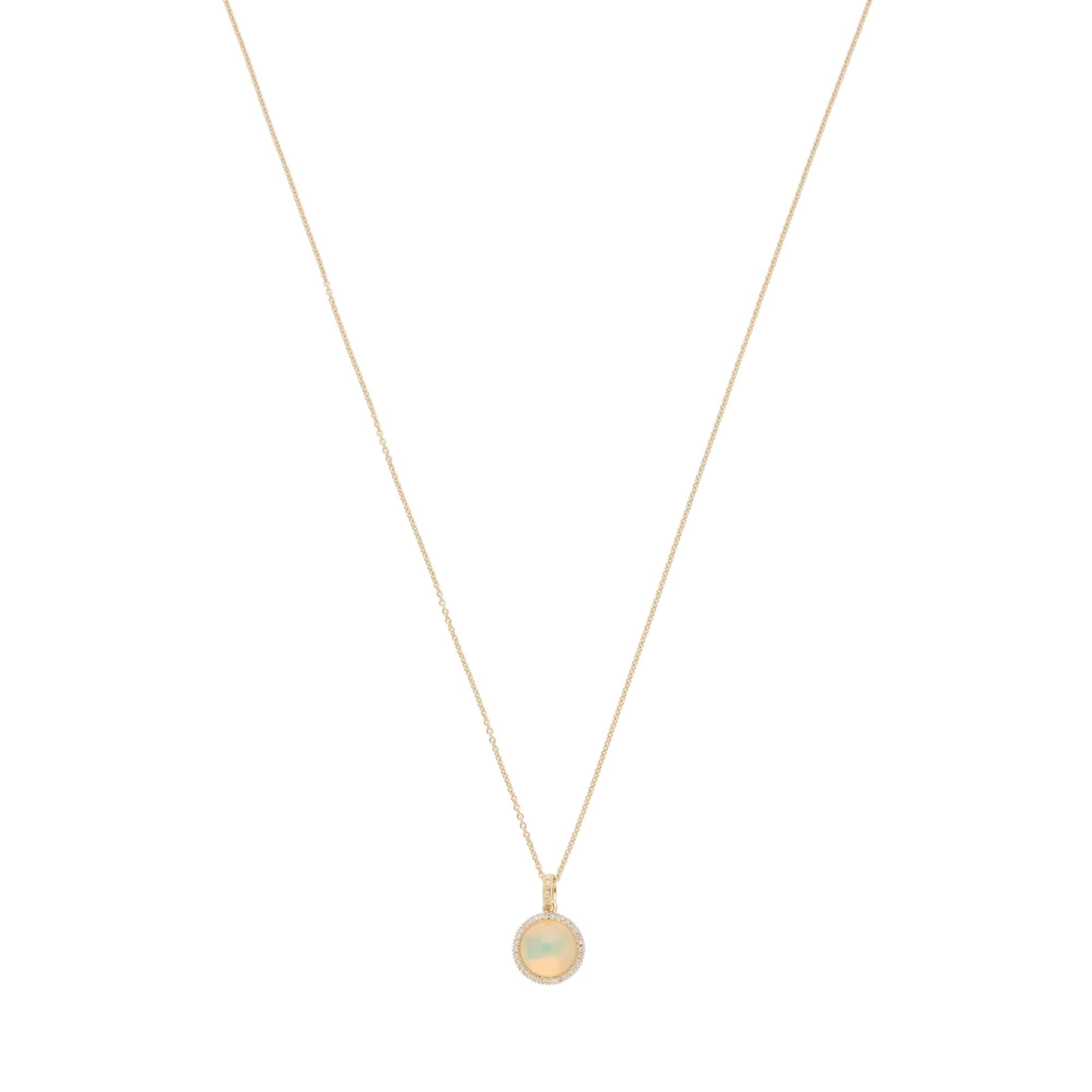 An elegant contemporary precious opal and diamond halo pendant necklace set in 18k yellow gold.

The pendant is centrally set with a large round cabochon precious opal. This opal is haloed by 32 round brilliant-cut diamonds. These diamonds are