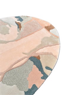 Alfombra contemporánea de forma orgánica en suaves tonos melocotón, arena y verde azulado apagado