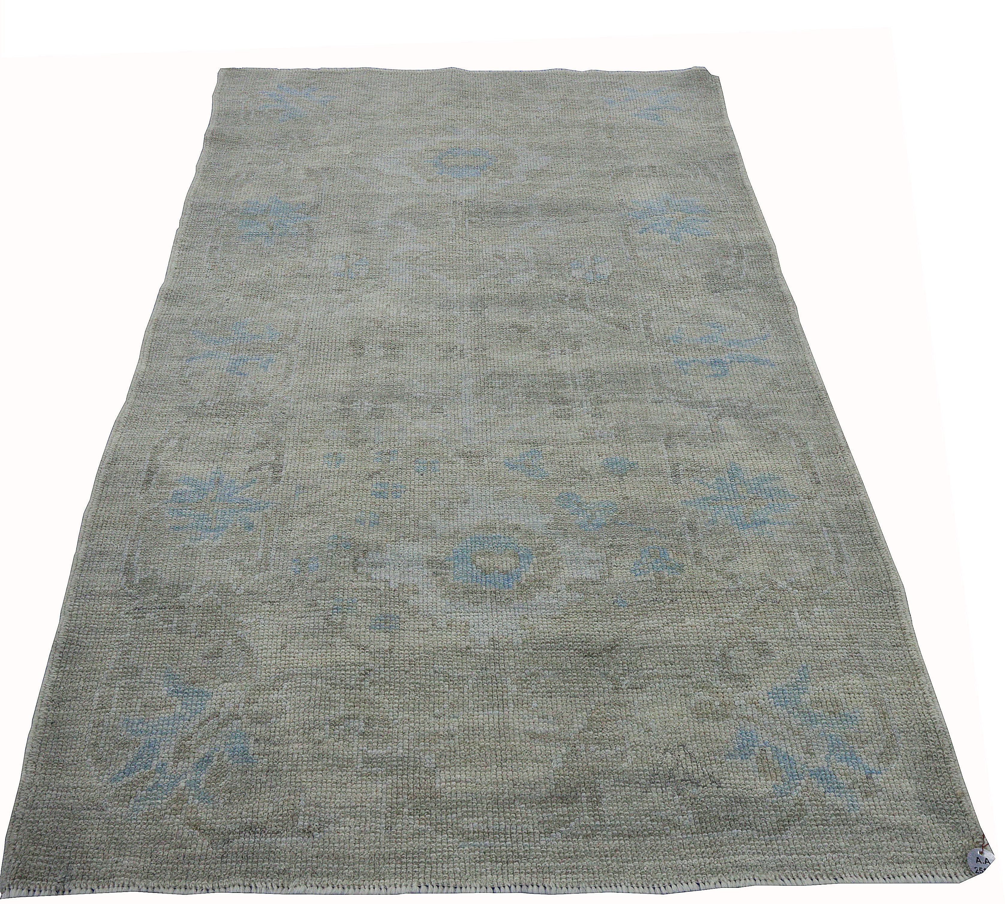 Contemporary Turkish rug made of handwoven sheep’s wool of the finest quality. It’s colored with organic vegetable dyes that are certified safe for humans and pets alike. It features a gorgeous beige field with floral details in blue and gray