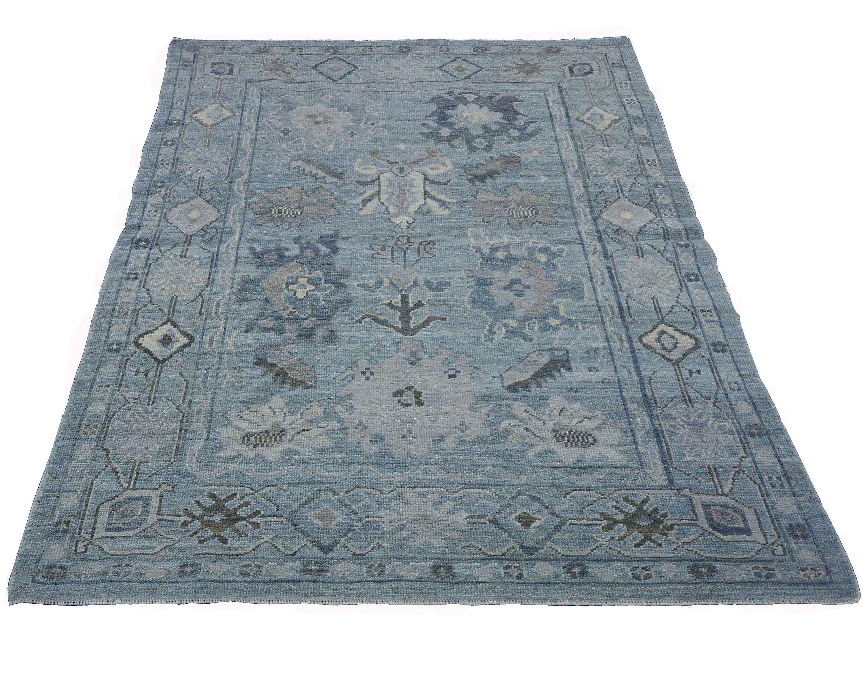 Contemporary Turkish rug made of handwoven sheep’s wool of the finest quality. It’s colored with organic vegetable dyes that are certified safe for humans and pets alike. It features a gorgeous blue field with floral details in navy, white and gray