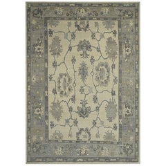 Tapis contemporain Oushak à motifs floraux en bleu et gris sur fond ivoire