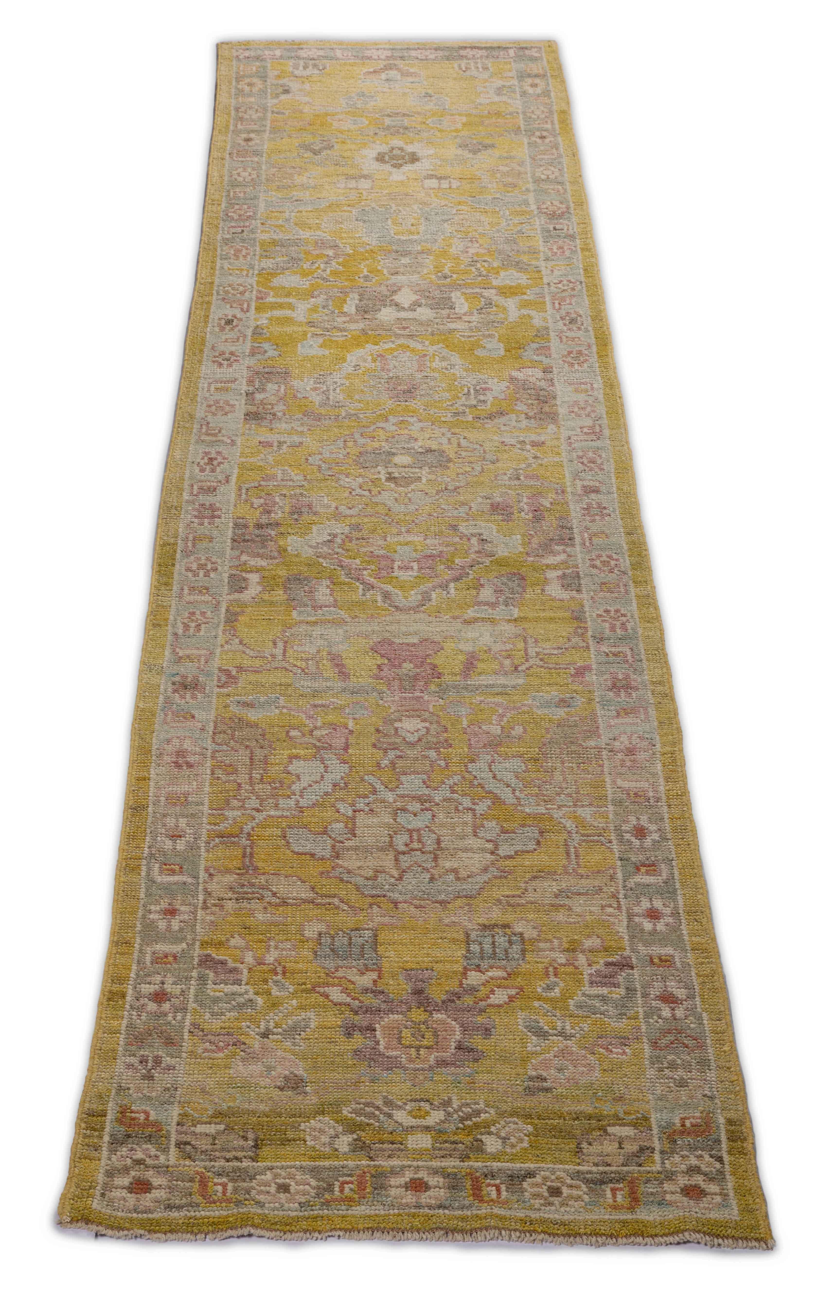  New Turkish runner rug made of handwoven sheep’s wool of the finest quality. It’s colored with organic vegetable dyes that are certified safe for humans and pets alike. It features a long, gray field with flower details allover in gold and pink
