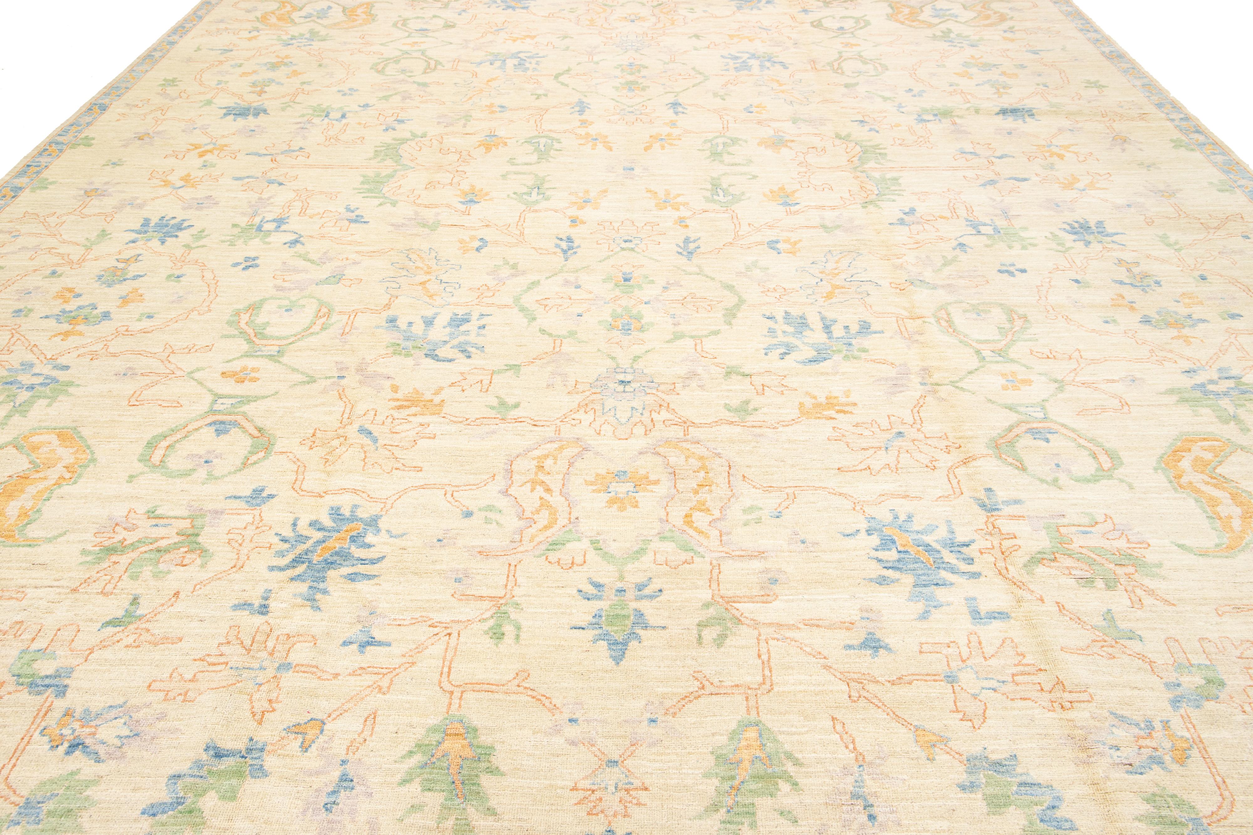 Ce tapis contemporain en laine de style Oushak allie admirablement le design moderne au charme intemporel de l'artisanat traditionnel Oushak. Il présente un fond beige remarquable, orné de motifs floraux éclatants.

Ce tapis mesure 12'1