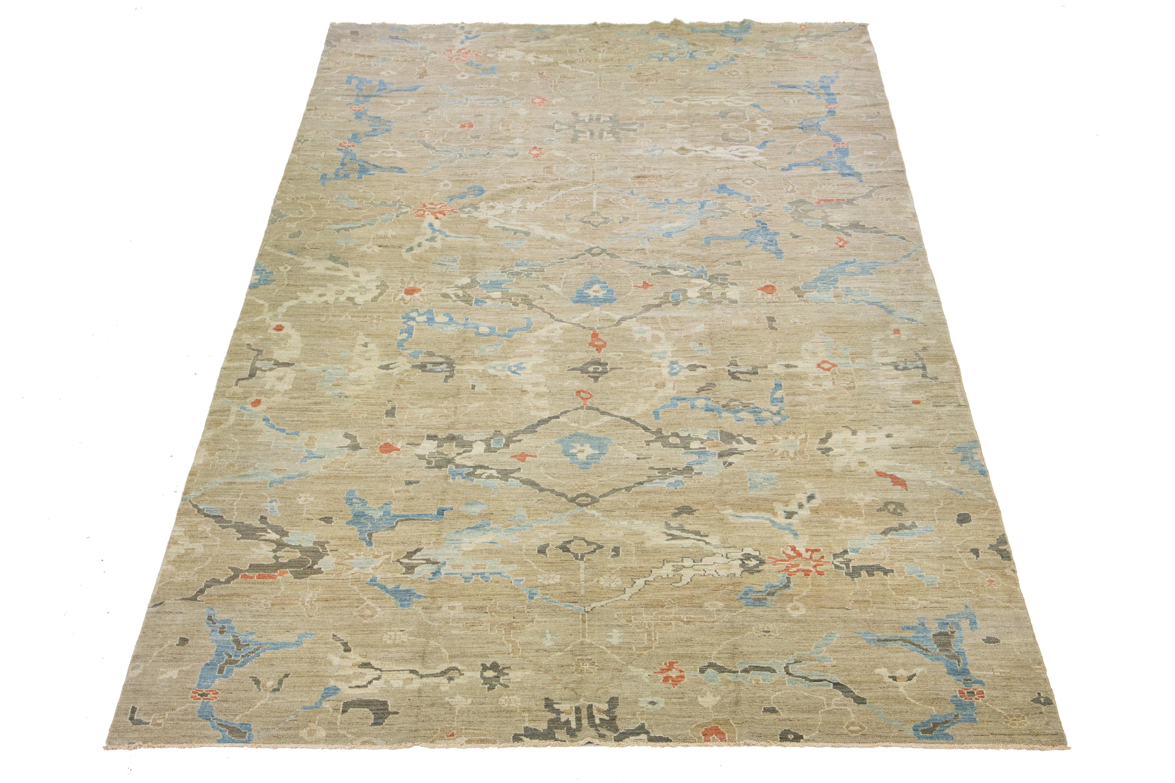 This exceptional oversized Oushak Style wool rug features a charming brown color base and is hand-knotted with utmost attention to detail. With stunning blue, gray, and beige accents, it displays a captivating floral pattern that is alluring to any