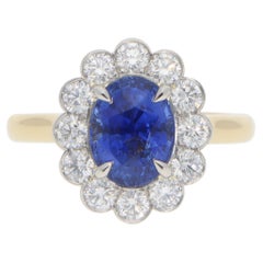 Anello contemporaneo con zaffiro blu ovale e diamanti a grappolo