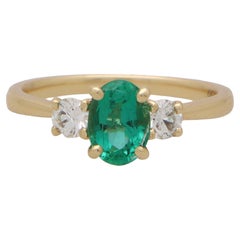 Contemporary Oval Emerald and Round Cut Diamond Three Stone Rin in 18k Gold